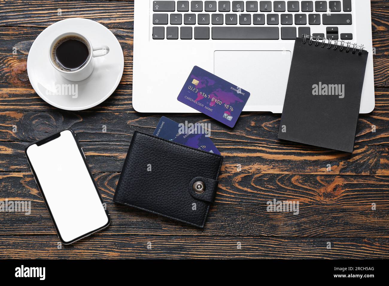 Laptop with cup of coffee, wallet and credit cards on brown wooden background Stock Photo