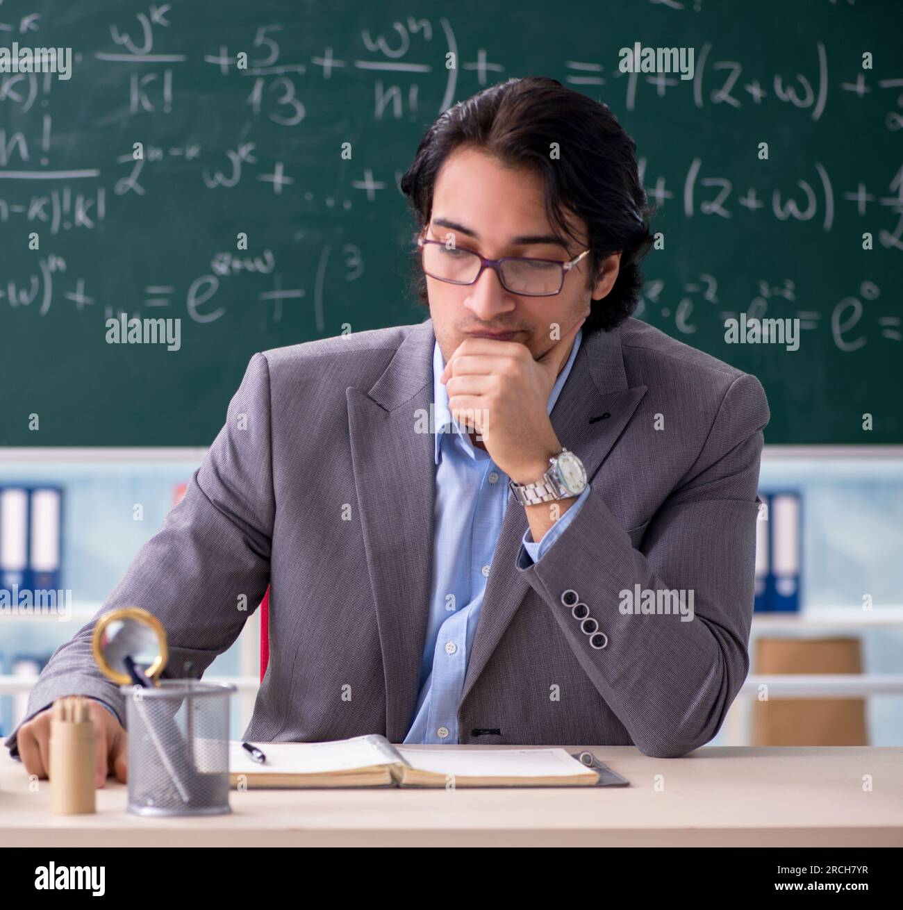 The young handsome math teacher in classroom Stock Photo