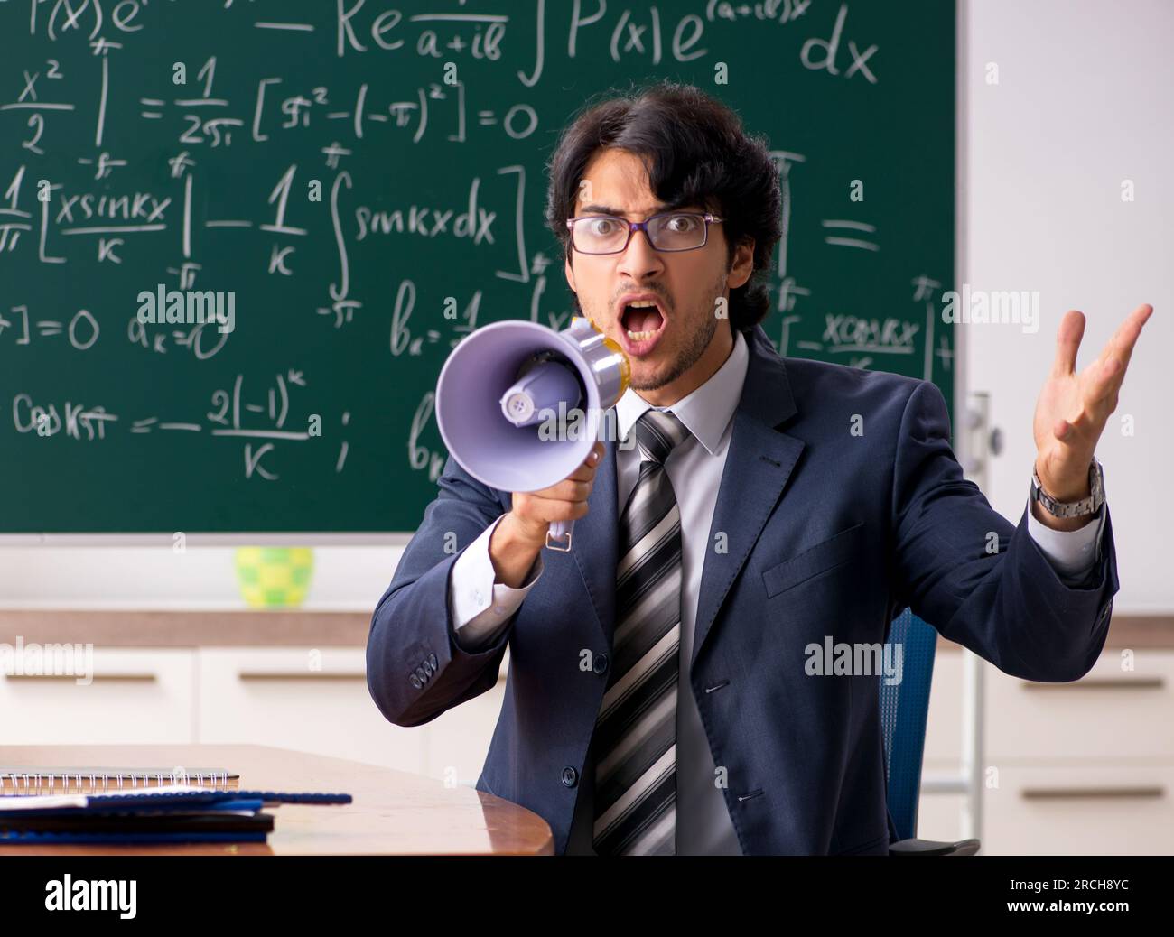 The young male math teacher in classroom Stock Photo - Alamy