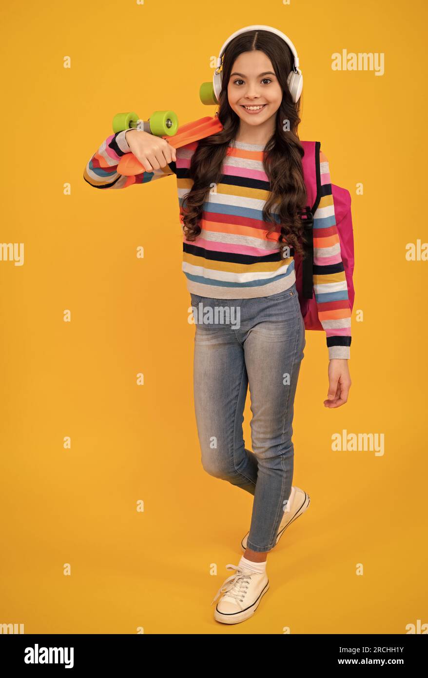 Studio shot of trendy teenage fashion model in casual look. Teenager youth hipster urban lifestyle. Child girl in street style with a skateboard. Happ Stock Photo Alamy