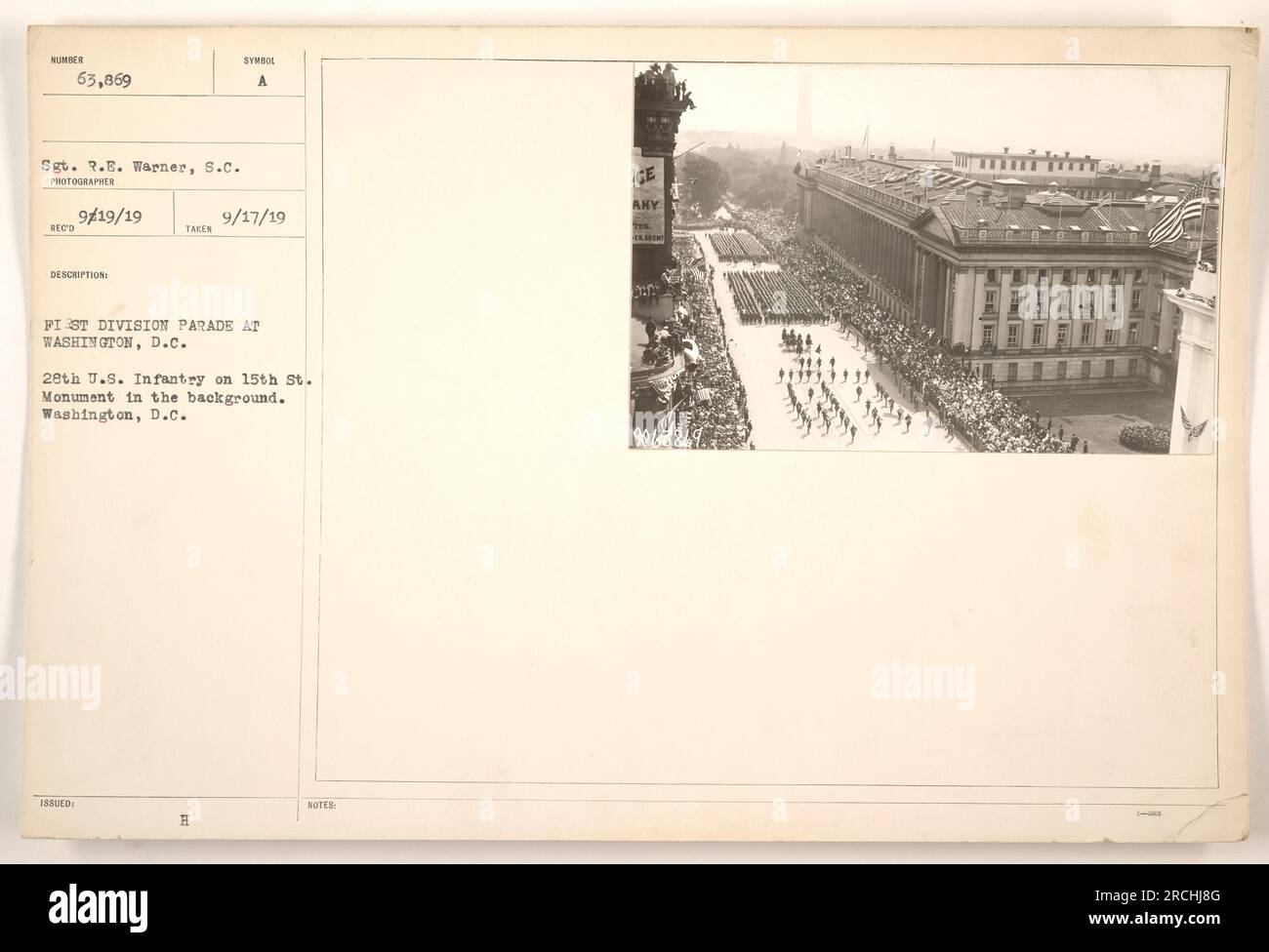 Parade of the First Division at Washington, D.C. with the 28th U.S. Infantry on 15th Street. The Washington Monument is visible in the background. This photograph was taken by Sgt. R.E. Warner, S.C. on September 19, 1919. The image is from the collection titled 'Photographs of American Military Activities during World War One.' Stock Photo