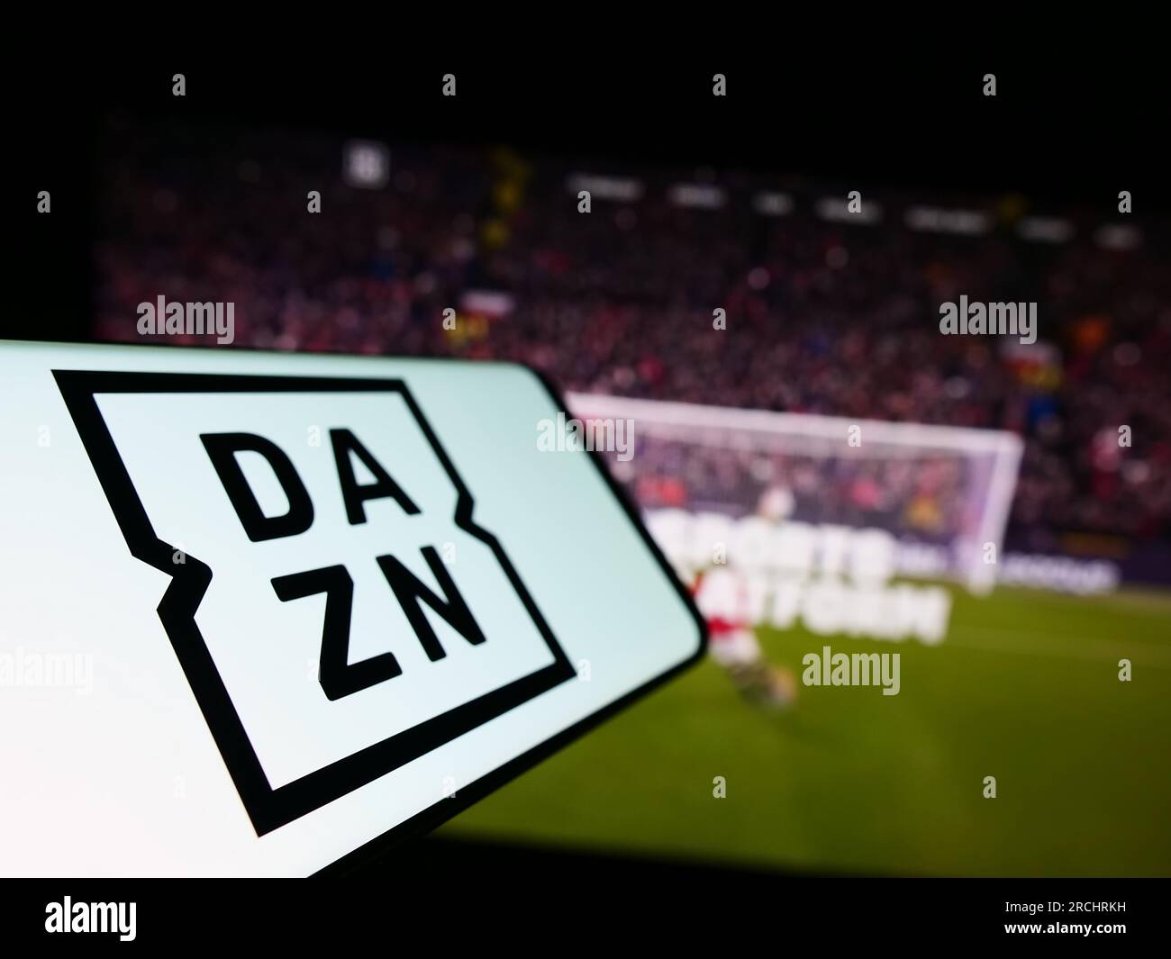 Smartphone with logo of British sports media company DAZN Group Limited on screen in front of business website