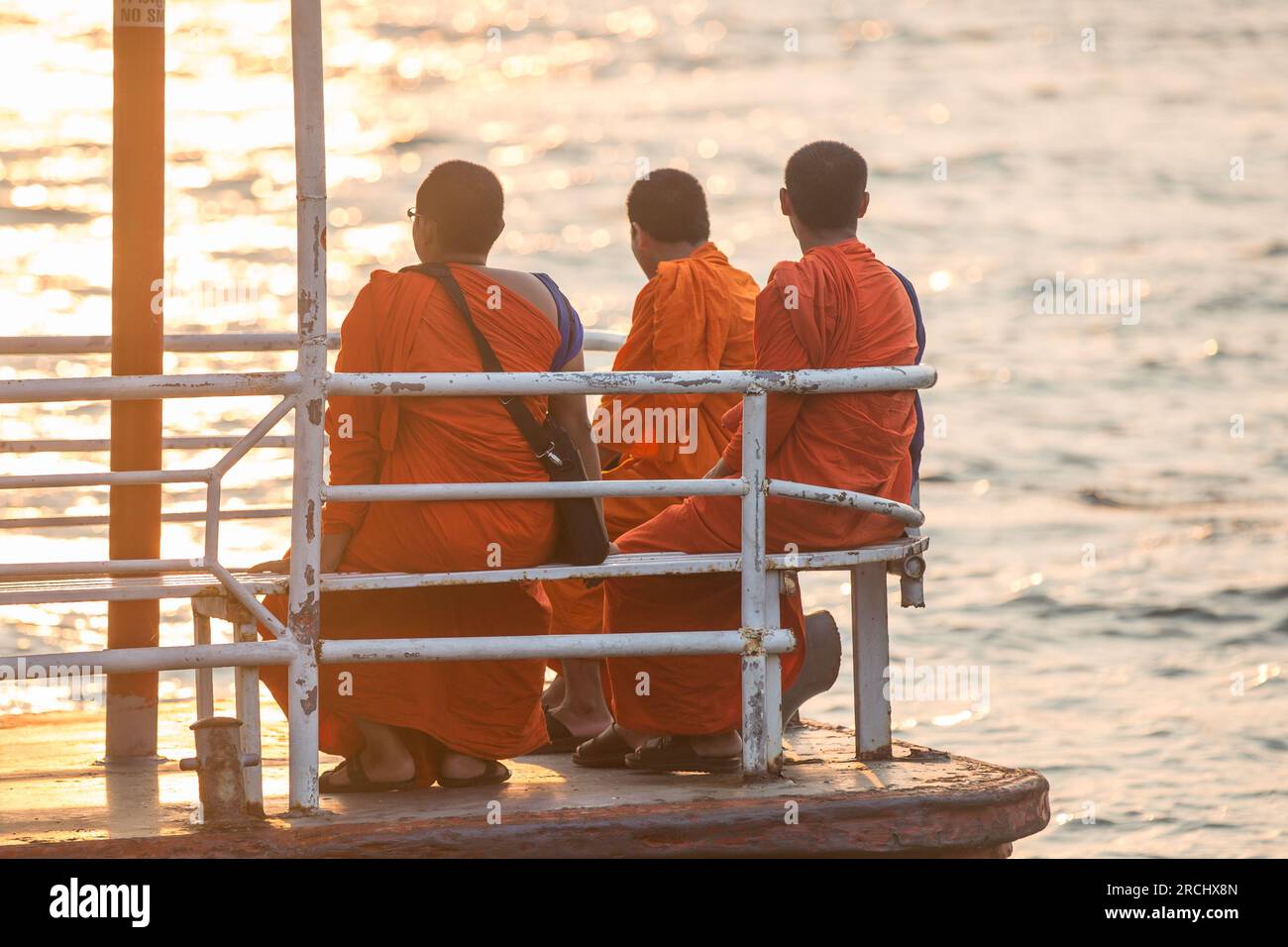 Buddhist monks sitting by the river Stock Photo - Alamy