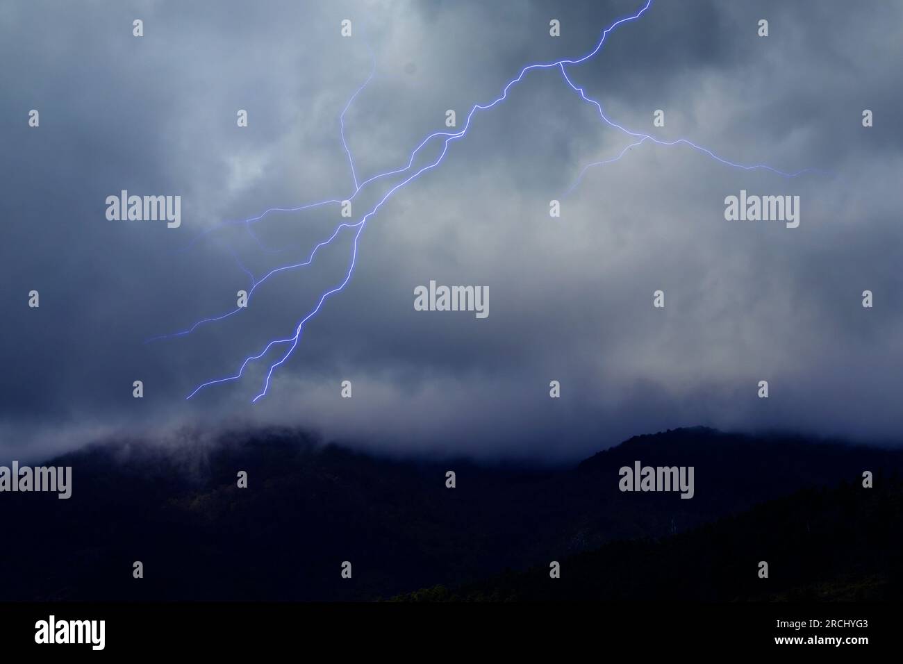 Lightning in the Dark Sky with Storm Clouds Over the Mountains Stock ...