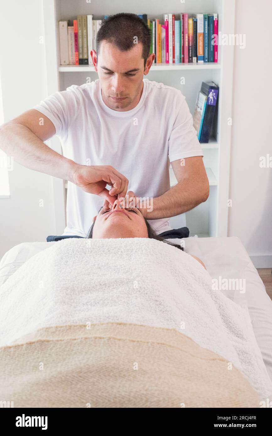 Therapist doing nose alignment treatment to help patient breathe better