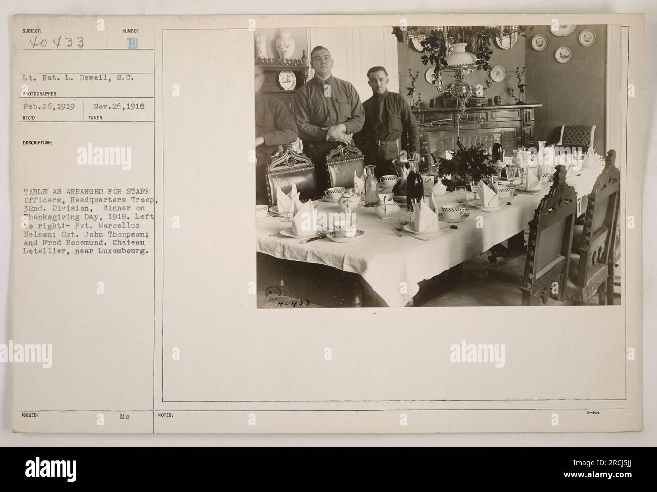 Caption: 'Staff officers from Headquarters Troop, 32nd Division, celebrating Thanksgiving Day with a dinner at Chateau Letellier near Luxembourg. Pictured from left to right: Pvt. Marcellus Nelson, Sgt. John Thompson, and Fred Rosemund. Photo taken on November 26, 1918, by Lt. R. L. Dewell, S.C.' Stock Photo