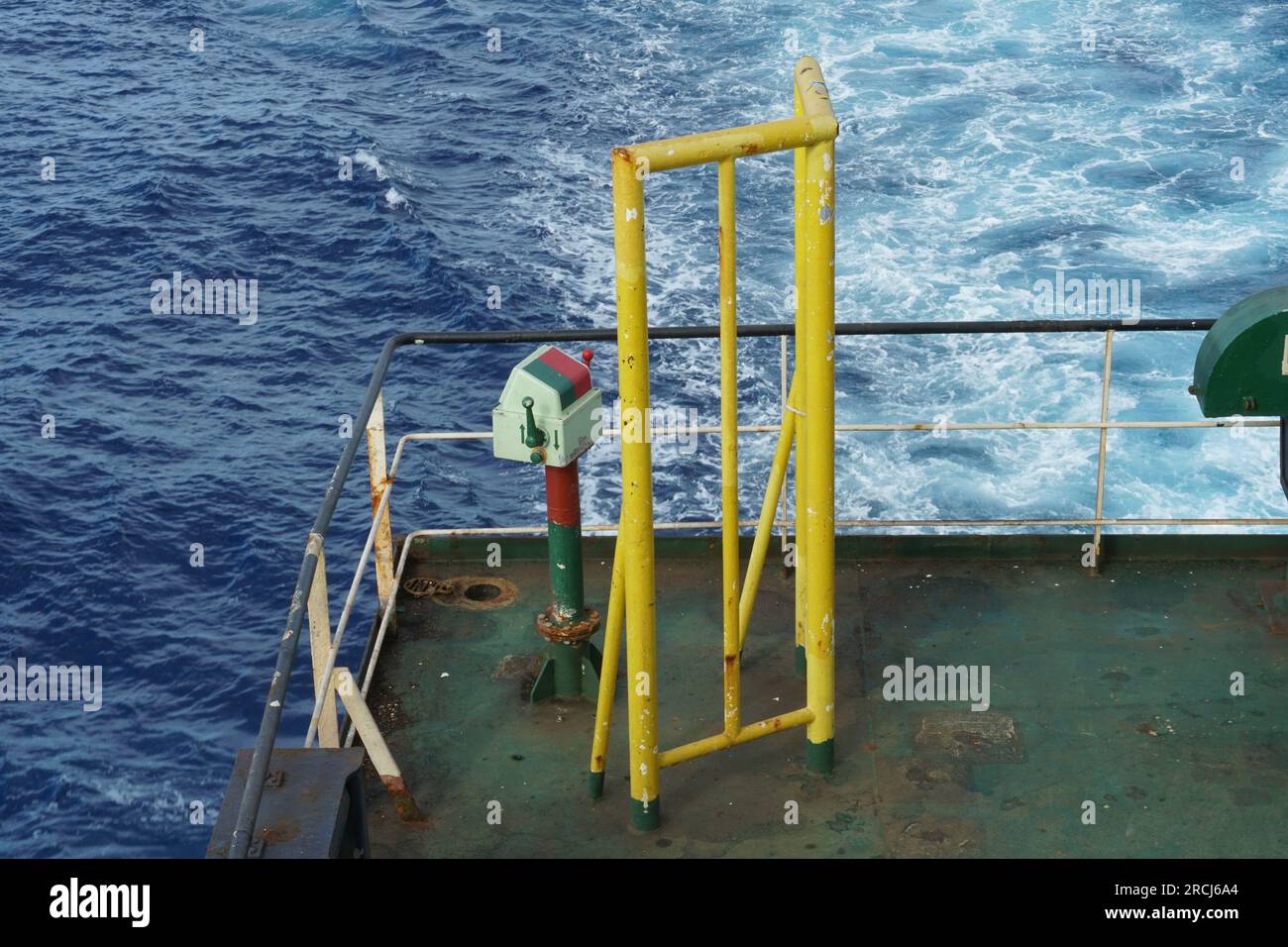 Control station of ship afterdeck mooring winch behind yellow construction to protect winch operator. Stock Photo