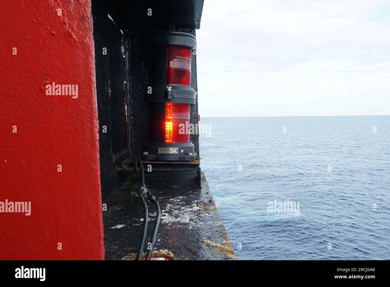 Red port side navigational lights of ship is situated next to superstructure. Stock Photo