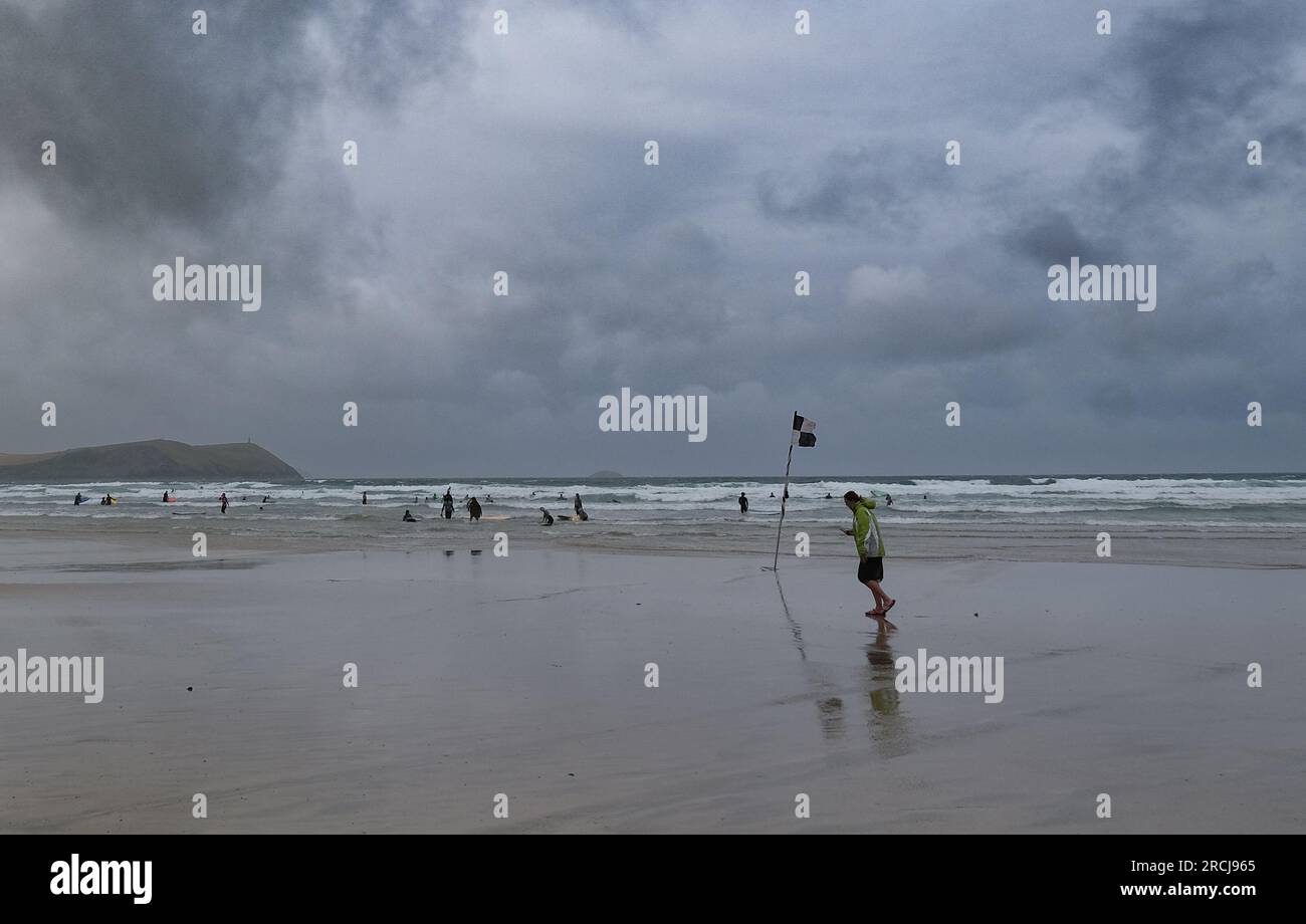 Polzeath, Cornwall, UK. 15th July 2023. UK Weather. Despite the strong winds and heavy showers people were still on the beach and in the sea at Polzeath this morning. Credit Simon Maycock / Alamy Live News. Stock Photo