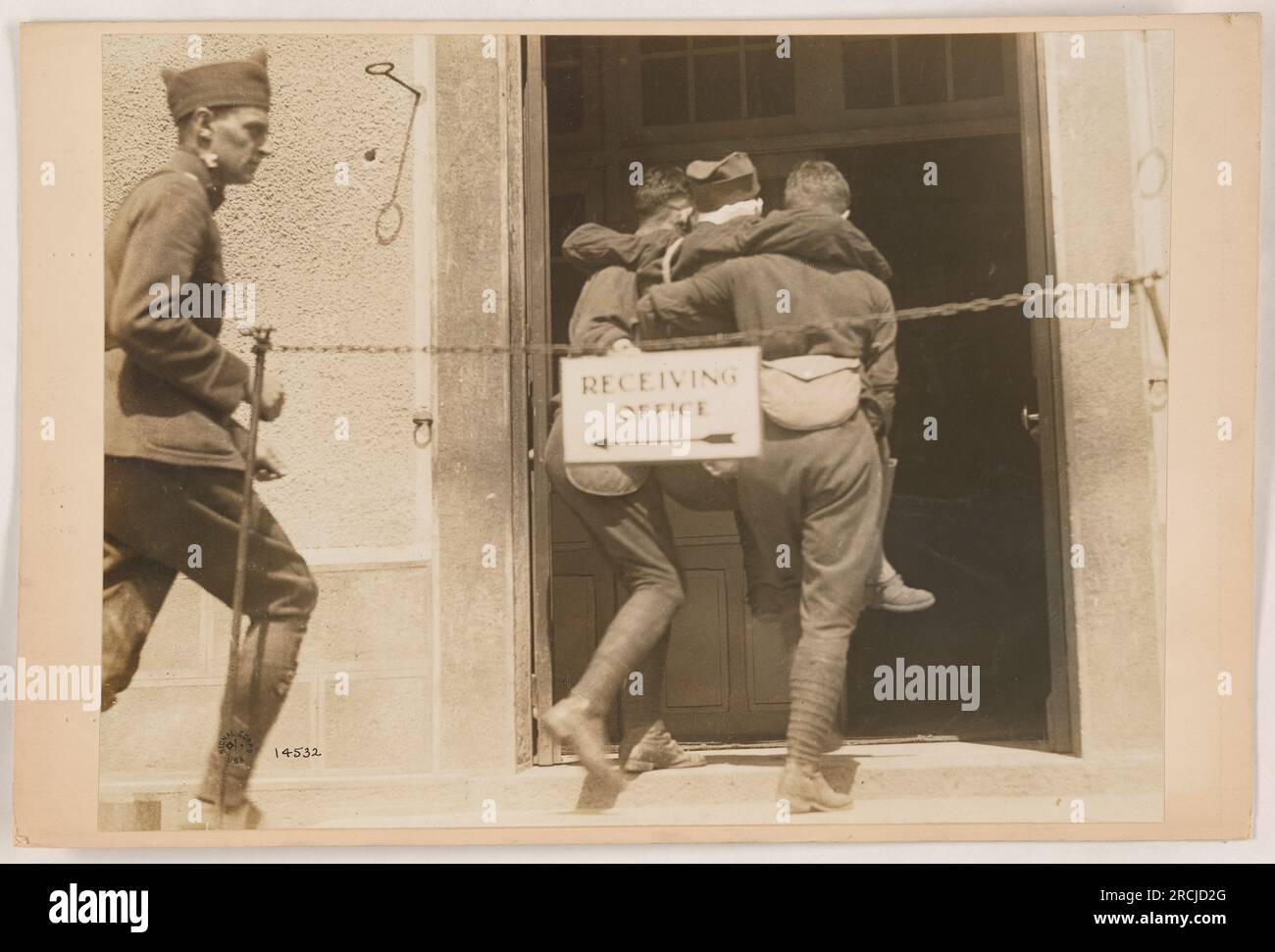 A photograph depicting a receiving office at an American military installation during World War One. Soldiers can be seen processing paperwork and sorting mail in an organized and efficient manner. Stock Photo