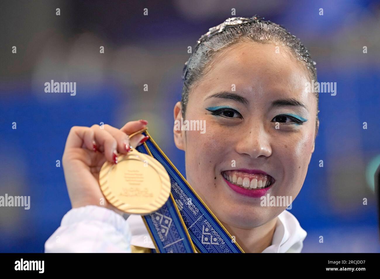 Yukiko Inui, of Japan, holds up her gold medal after winning the women
