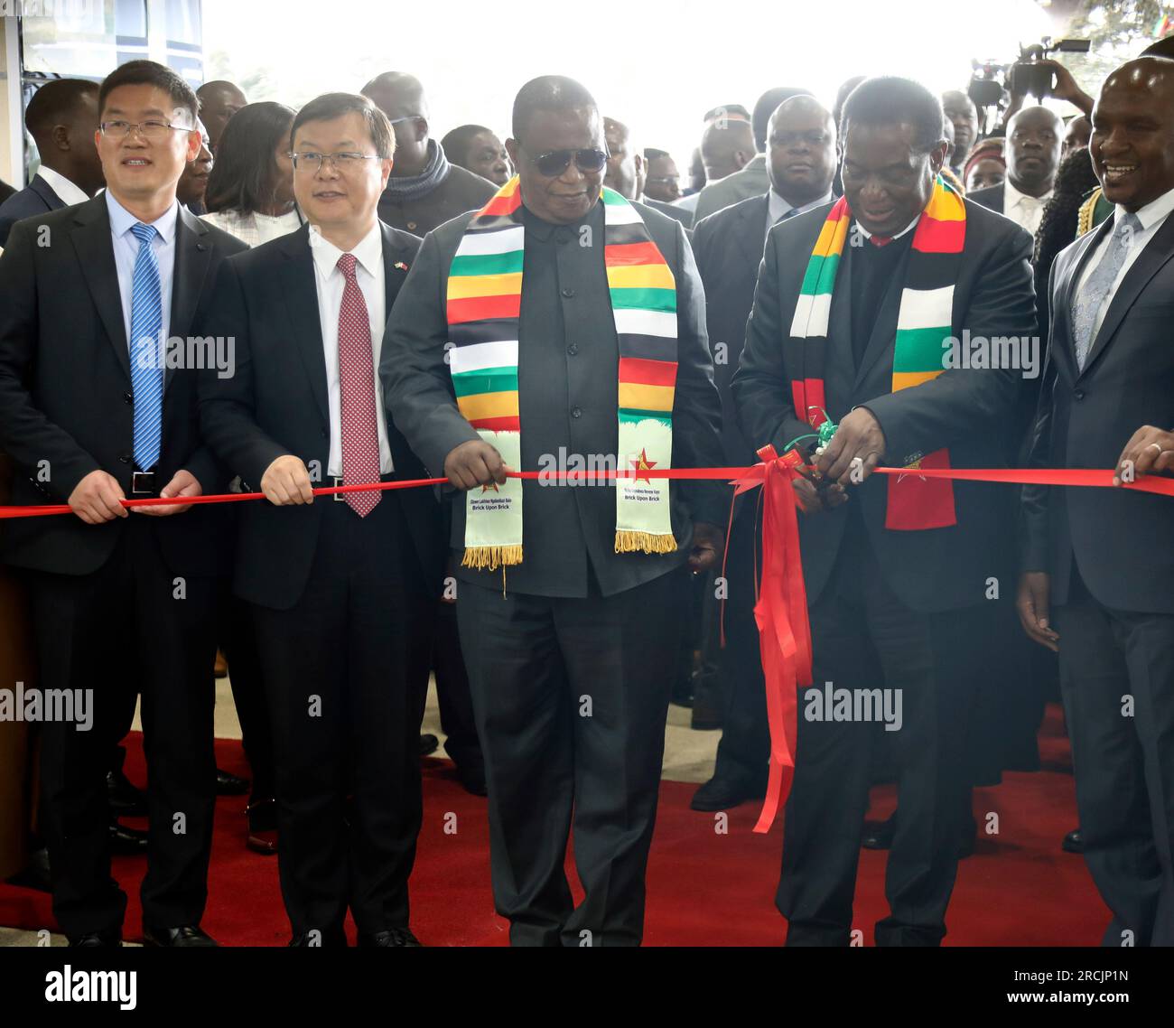 (230715) -- HARARE, July 15, 2023 (Xinhua) -- Zimbabwean President Emmerson Mnangagwa (2nd R, front) cuts the ribbon to commission the new Chinese-funded expanded terminal at Robert Gabriel Mugabe International Airport in Harare, Zimbabwe, July 14, 2023. Mnangagwa said the airport has brought positive effects to the country's economy, 'including skills and technology transfer, as well as the creation of employment and empowerment opportunities.'The project, expected to increase the airport's holding capacity to 6 million people per annum from 2.5 million when all is accomplished, consists of a Stock Photo