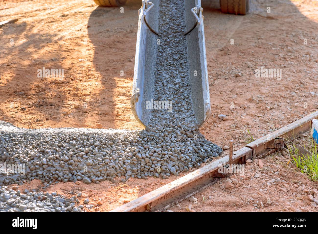 In driveway near home concrete mixer truck pours readymixed cement