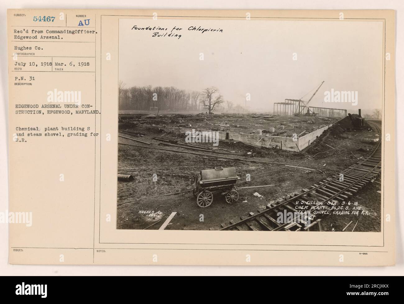 Construction of Edgewood Arsenal in Edgewood, Maryland. The image depicts a chemical plant building labeled 'S' and a steam shovel grading the area for railroad tracks. The photograph was taken on July 10, 1918, by Hughes Co. The foundations for the Chlorpicrin Building are noted. Stock Photo