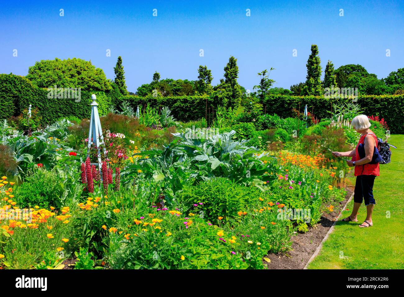 A lady visitor admiring the colourful Formal Flower Garden at the Holme