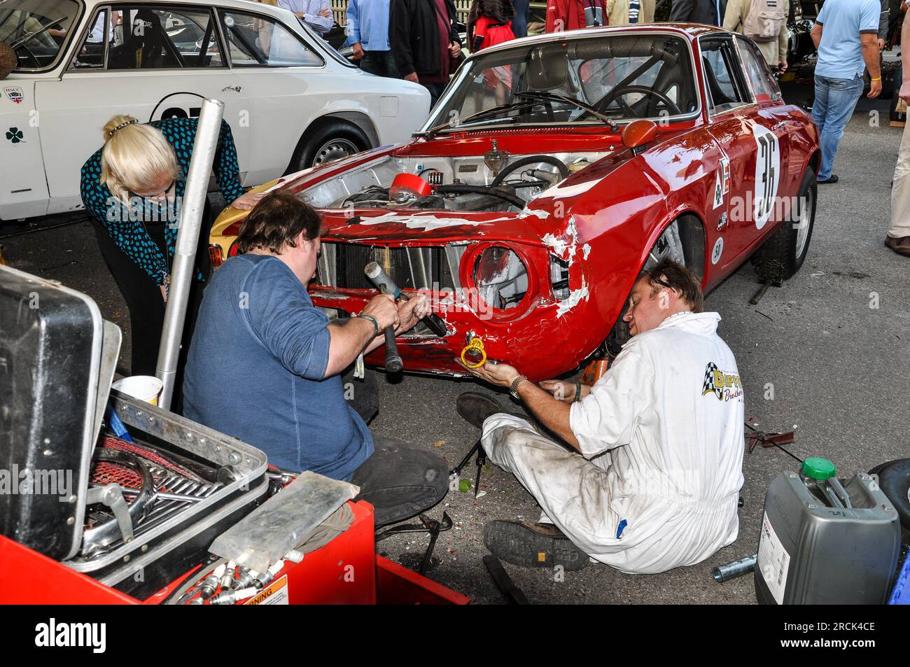 Mechanics working on a crash damaged Alfa Romeo 1600 GTA in the garage