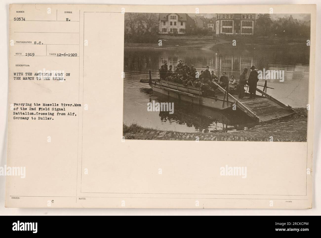 American soldiers from the 2nd Field Signal Battalion cross the Moselle River in Germany while marching to the Rhine. The ferry takes them from Alf to Bullav. The photograph was taken on Dec 6, 1920, by photographer S.C. Red as part of a series documenting American military activities during World War I. Stock Photo