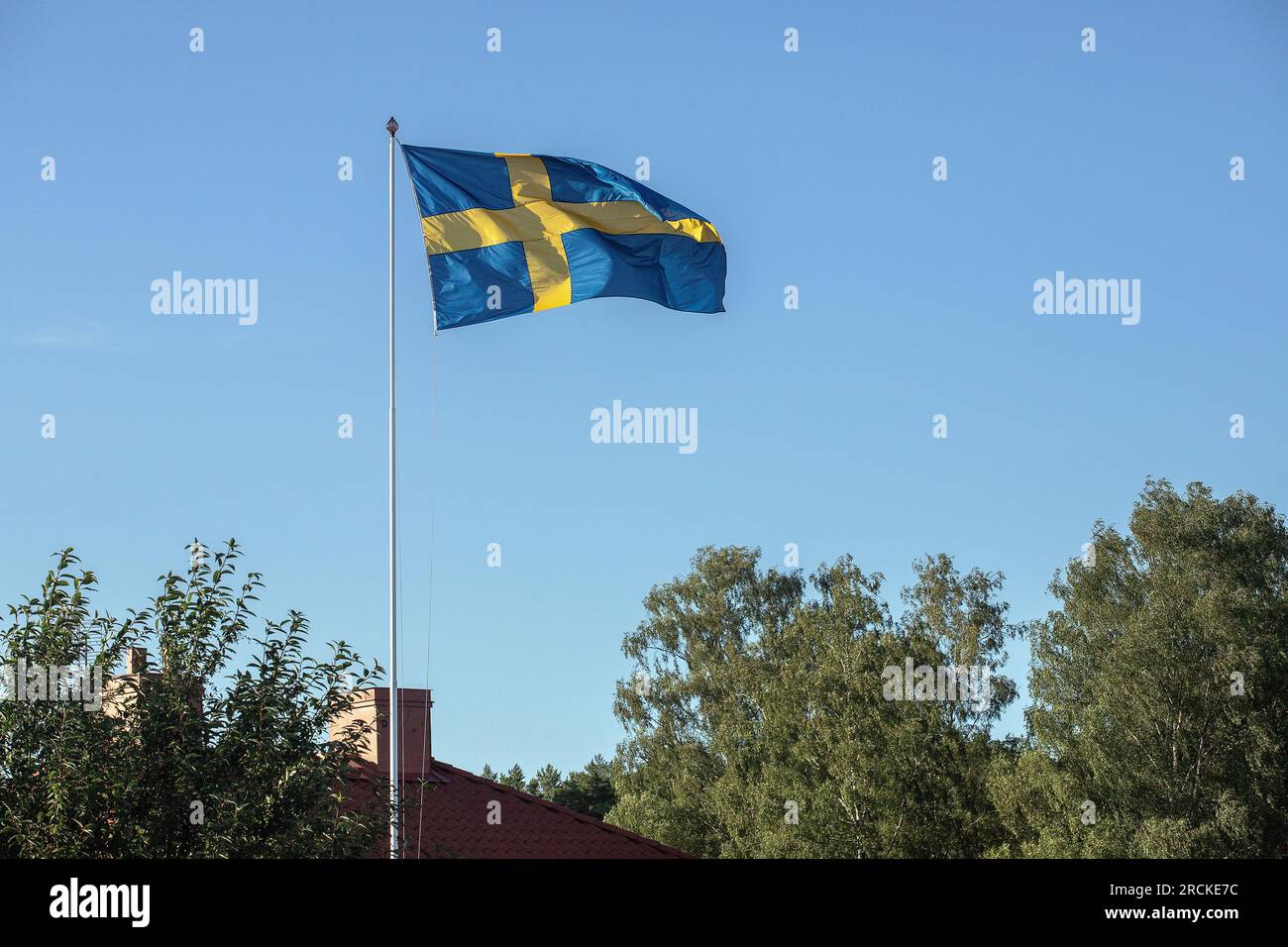 The Swedish flag flying against a bright blue sky. Malmkoping sweden