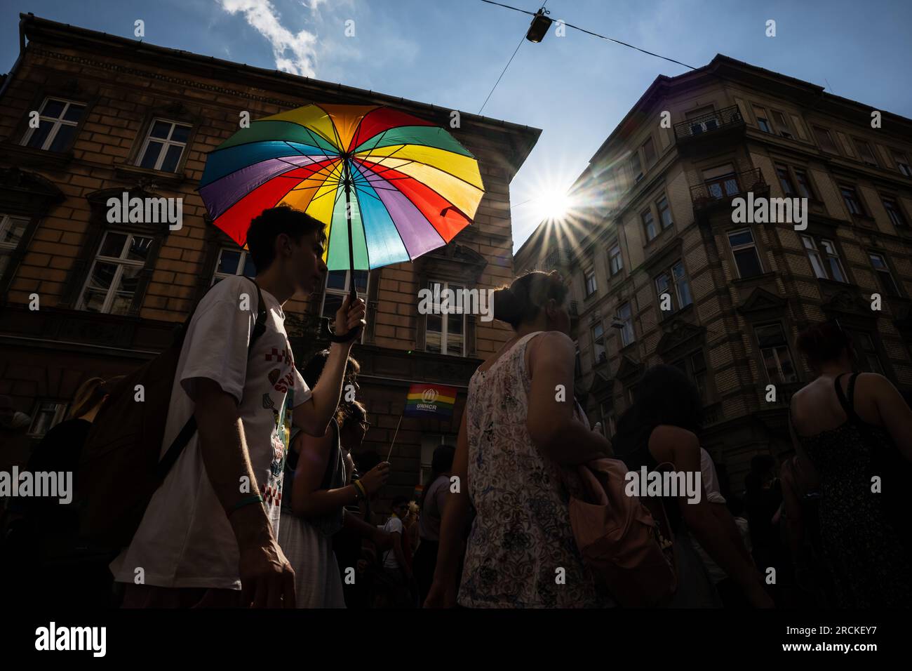 Budapest, Hungary. 15th July, 2023. A man takes part in the Pride parade in Budapest with a rainbow-colored umbrella. For the past two years, Hungary has had a so-called 'child protection law' that falsely equates homosexuality with pedophilia. The law prohibits providing young people with information about homosexuality, transsexuality or gender reassignment. Credit: Marton Monus/dpa/Alamy Live News Stock Photo