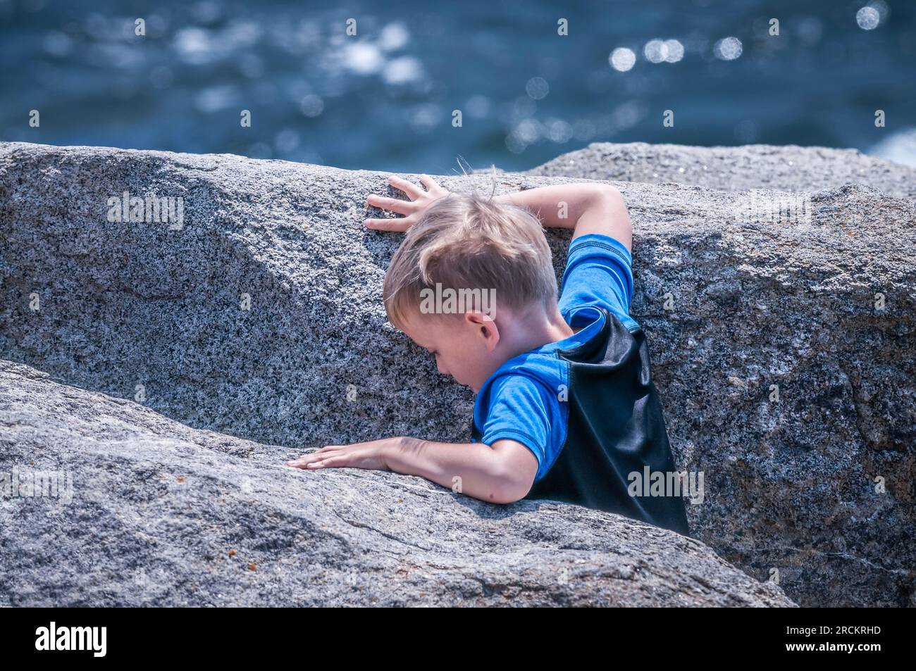 Between two rocks, and the ocean.This little trying to get to the edge of the ocean, went down two large rock. He did not find the ocean, but trouble. Stock Photo