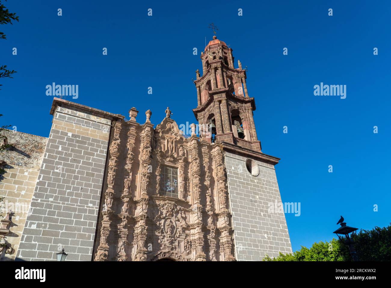 Façade of the Templo de San Francisco de Asís against a deep blue sky