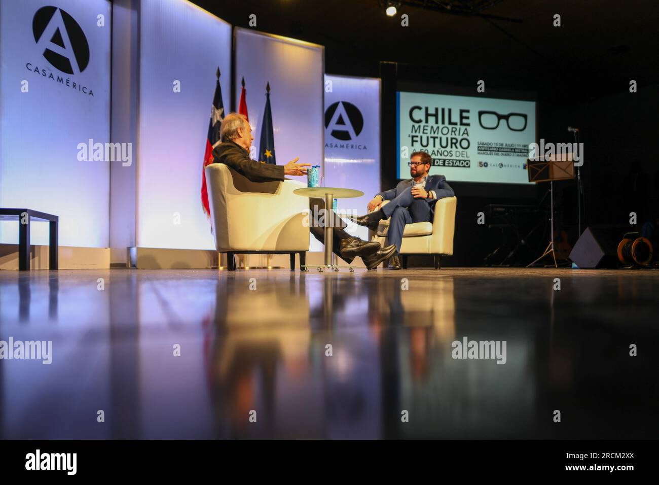 Madrid, Spain. 15th July, 2023. The President of the Republic of Chile, Gabriel Boric (R), talks with the Spanish singer-songwriter Joan Manuel Serrat (L) during the event. Taking advantage of the visit to Madrid of the President of the Republic of Chile. Gabriel Boric, Casa de América and the Chilean embassy in Madrid have organized an act in commemoration of the next 50th anniversary of the coup d'état in the South American country called: 'Memory and future 50 years after the coup d'état'. Coup led by General Augusto Pinochet against President Salvador Allende. Stock Photo