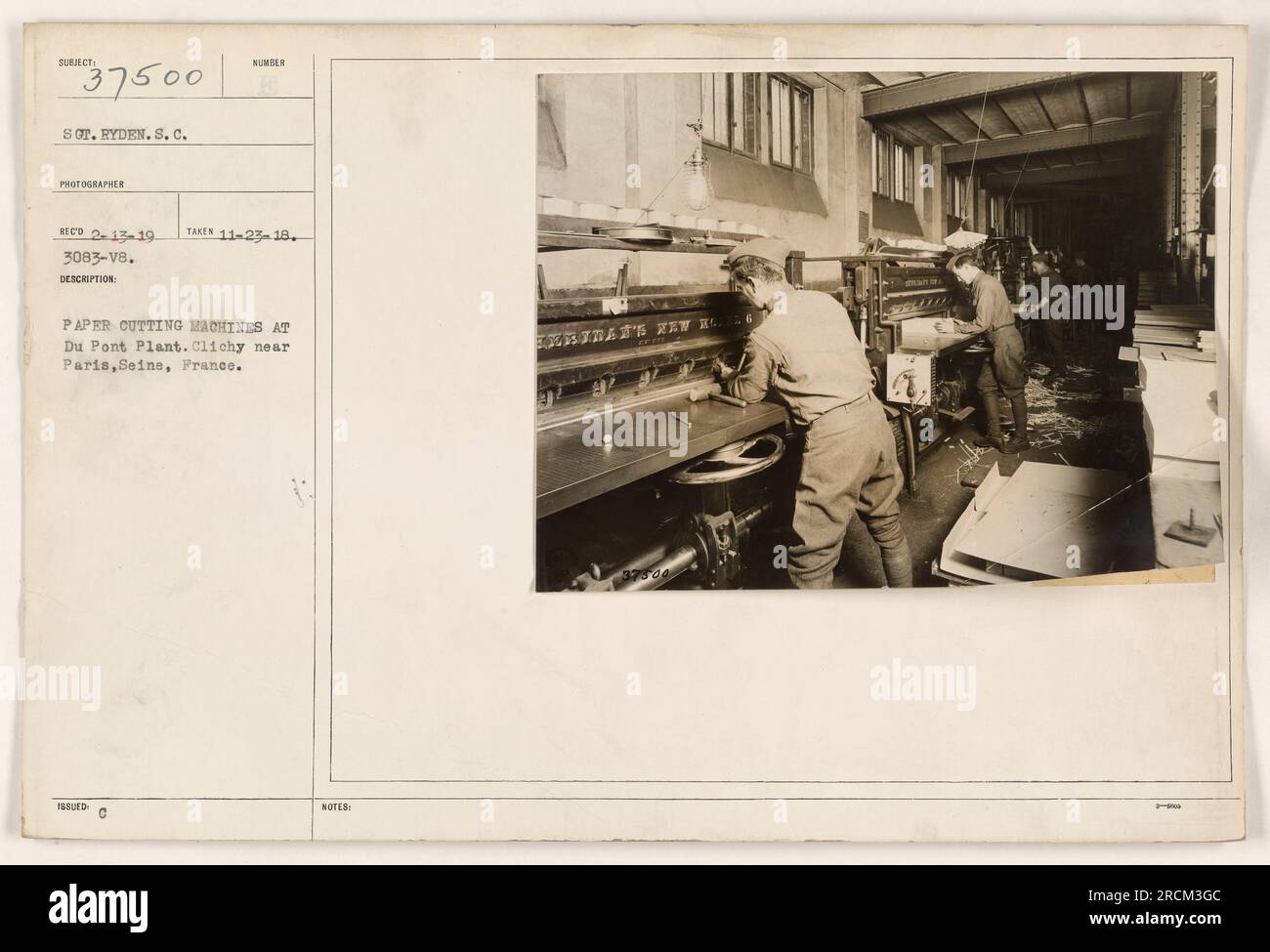 Soldiers working at paper cutting machines at the Du Pont Plant in Clichy near Paris, Seine, France during World War One. Photograph taken on November 23, 1918 by Sar. Ryden, photographer. Reference number: 111-SC-37500. Stock Photo