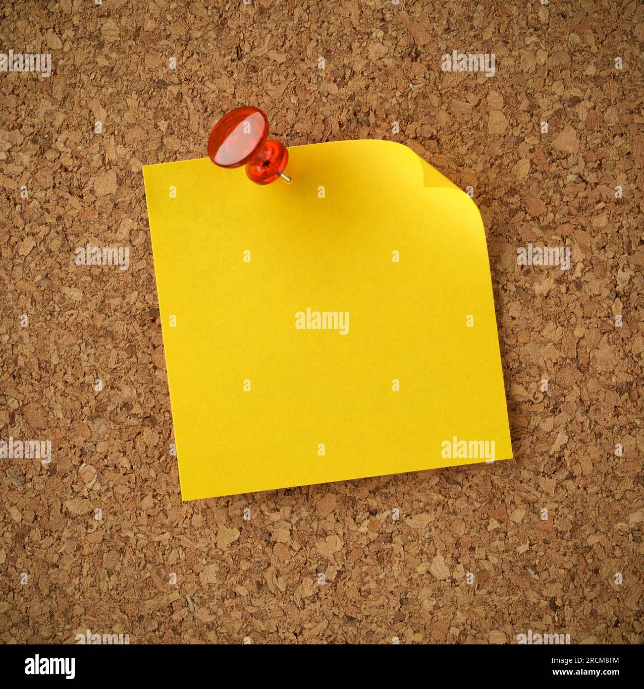 Blank yellow sticky note pinned with red tack. Empty copy space for important office notice, message, or reminder. Stock Photo