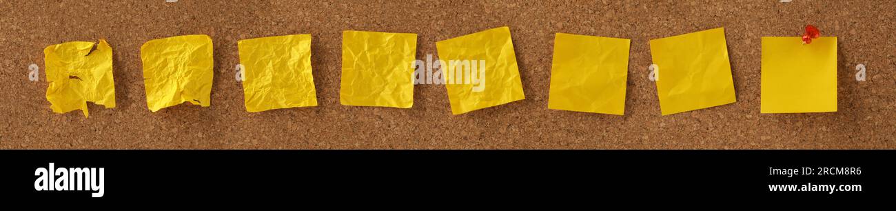 Blank yellow sticky notes on noticeboard with crumpled notes progressing to a smooth blank notice. Concept for the development or evolution of ideas. Stock Photo