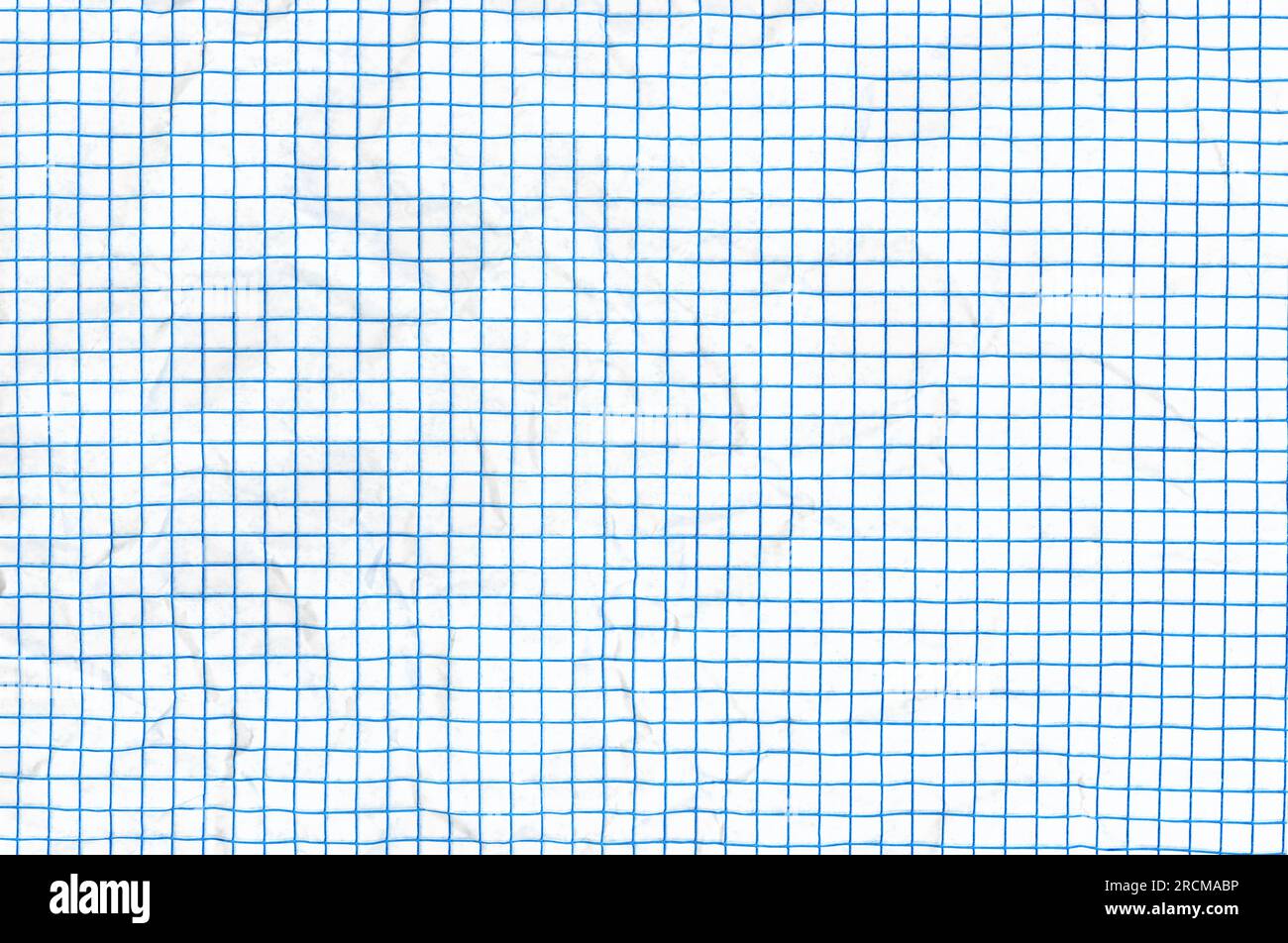 Crumpled blue lined graph or grid paper. Stock Photo
