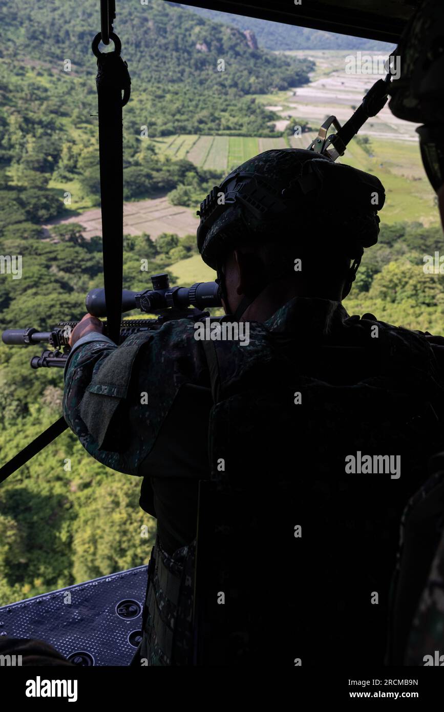 Philipine Marines conduct aerial sniper training aboard a U.S. Marine Corps UH-1Y Venom helicopter in Crow Valley, Philipenes, July 10, 2023. MASA is a bilateral exercise between the Armed Forces of Philippines and the U.S. Marine Corps, aimed at enhancing interoperability and coordination focused on aviation-related capabilities. During MASA 23, Filipino and U.S. Marines conduct different training evolutions including live-fire, air assaults, and subject matter expert exchanges across aviation, ground, and logistics capabilities. Stock Photo