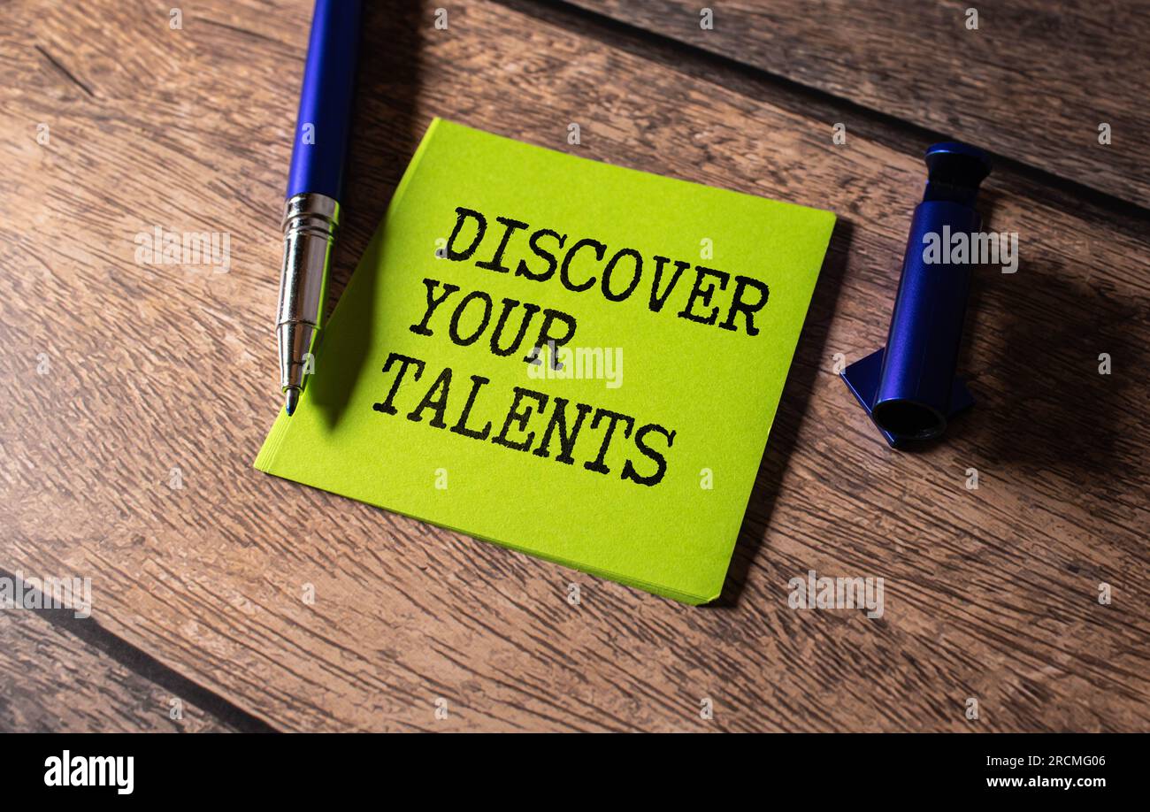 DISCOVER YOUR TALENTS - words on a pink piece of paper on a white notebook with glasses and pen. Stock Photo