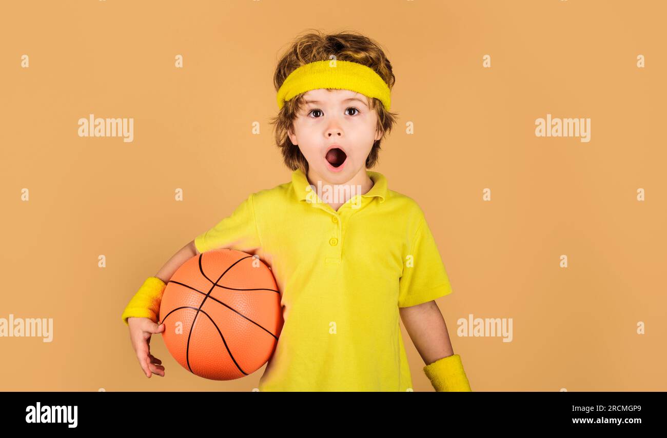 Active sport lifestyle, childhood. Basketball training session for kids. Surprised boy with basketball ball. Little basketballer in sportswear. Sport Stock Photo