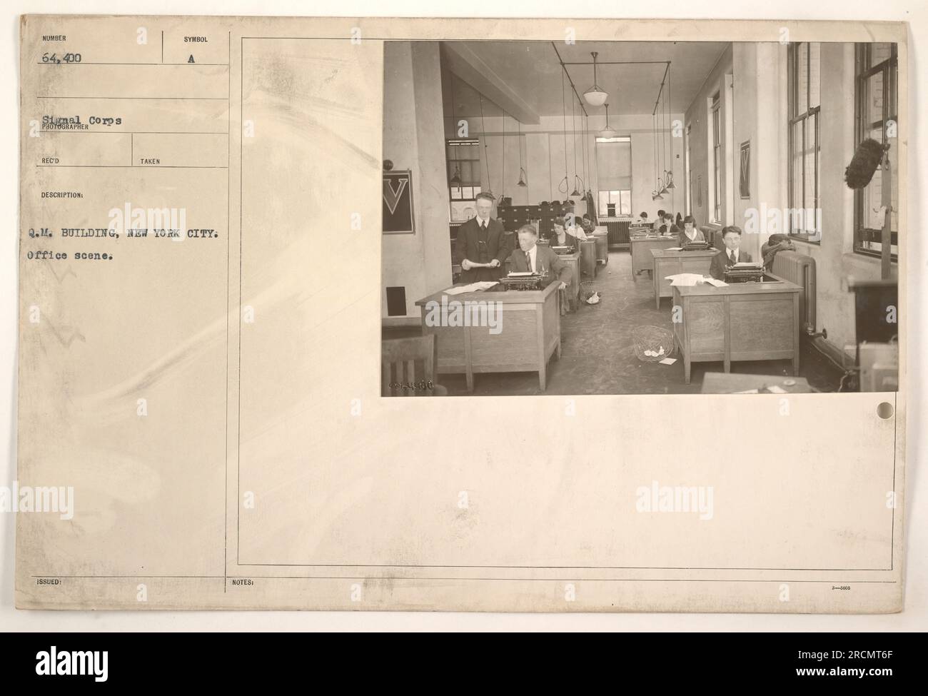The image shows an office scene inside the Q.M. Building in New York City during World War One. This particular photo has the identification number 64,400 and was recorded and described by the Corps. The photograph captures a typical office environment within the building. Stock Photo