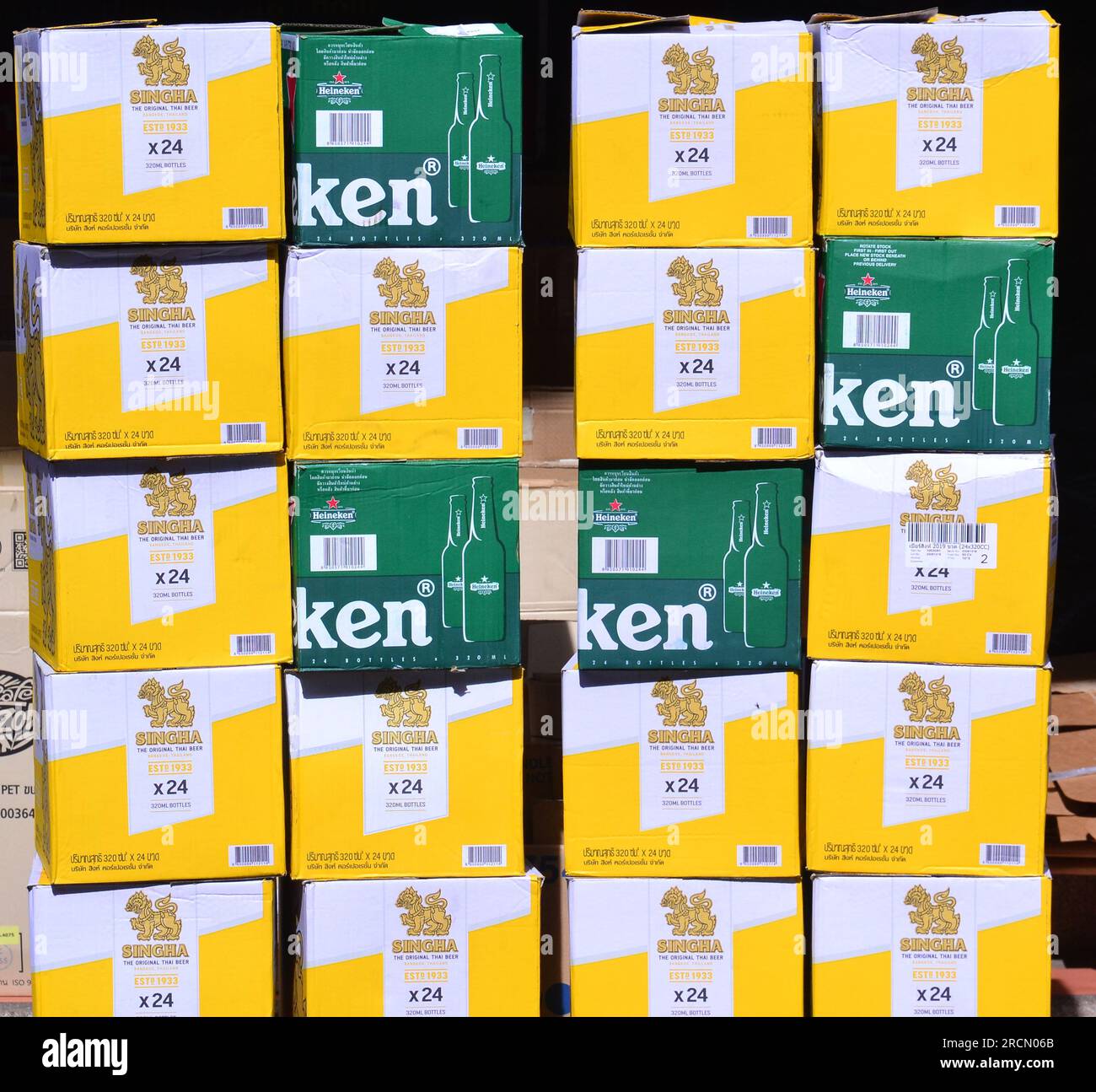 empty cardboard cases which use to hold glass bottles of singha beer and heineken beer, wait to be collected in a tourist area, patpong soi 2 , bangkok, thailand, for reuse or recycling Stock Photo