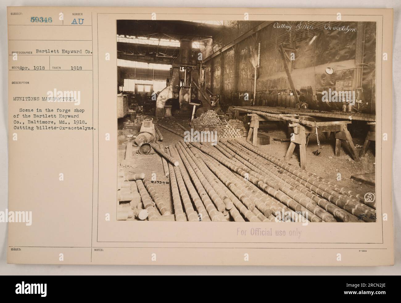 Scene in the forge shop of the Bartlett-Hayward Co. in Baltimore, Maryland in 1918. The workers are seen cutting billets using Ox-acetylene. This photograph was taken for documentation of munitions manufacturing during World War One. The image is labeled subject #59346 and was captured by the Bartlett Hayward Co. in April 1918. The photograph is marked 'For Official use only.' Stock Photo