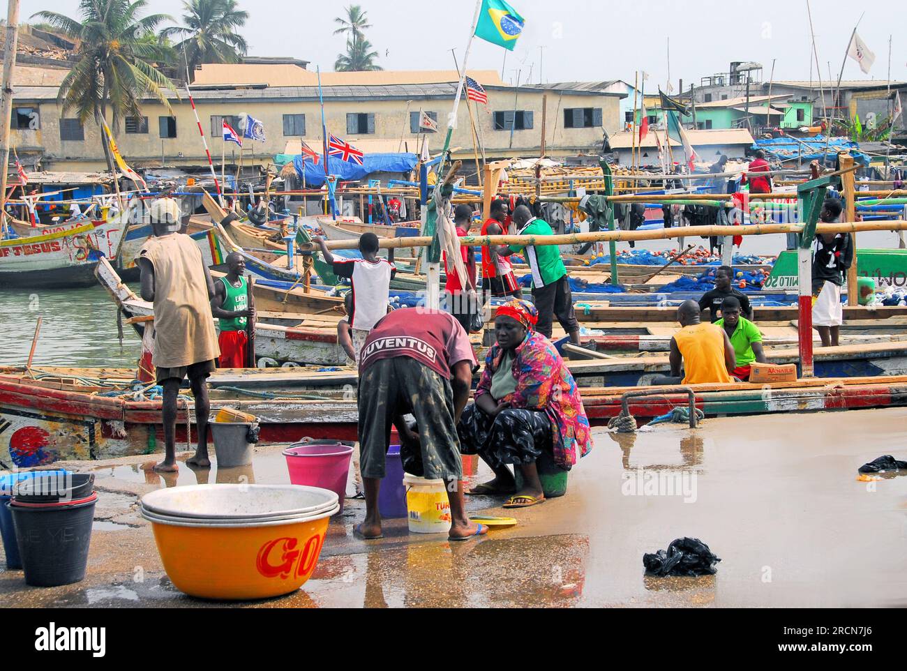 Fishing boats docking at fish market while people get ready to sell