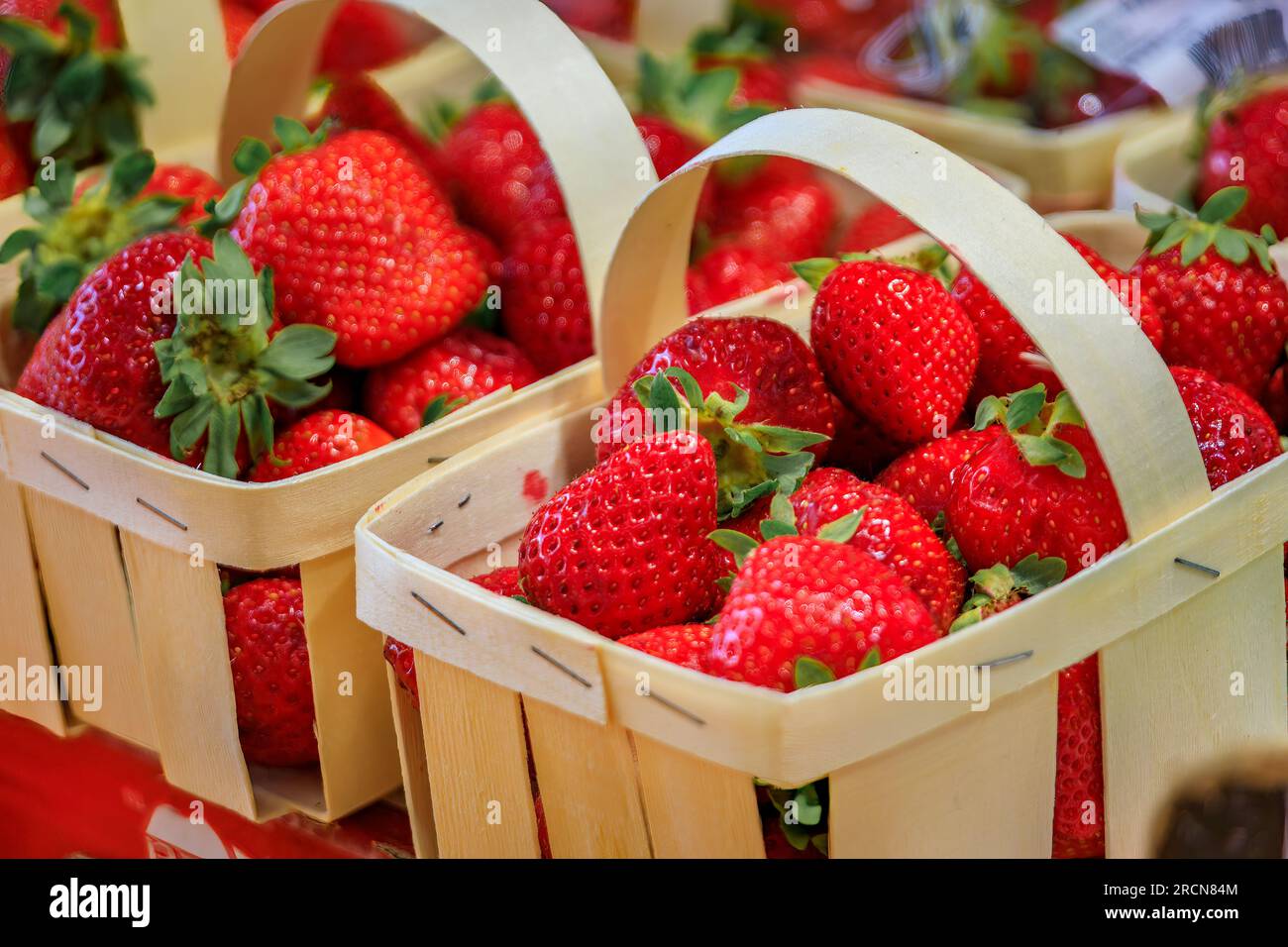 Ripe red strawberries on a stand at a local covered provencal farmers market hall in the old town or Vieil Antibes, South of France Stock Photo