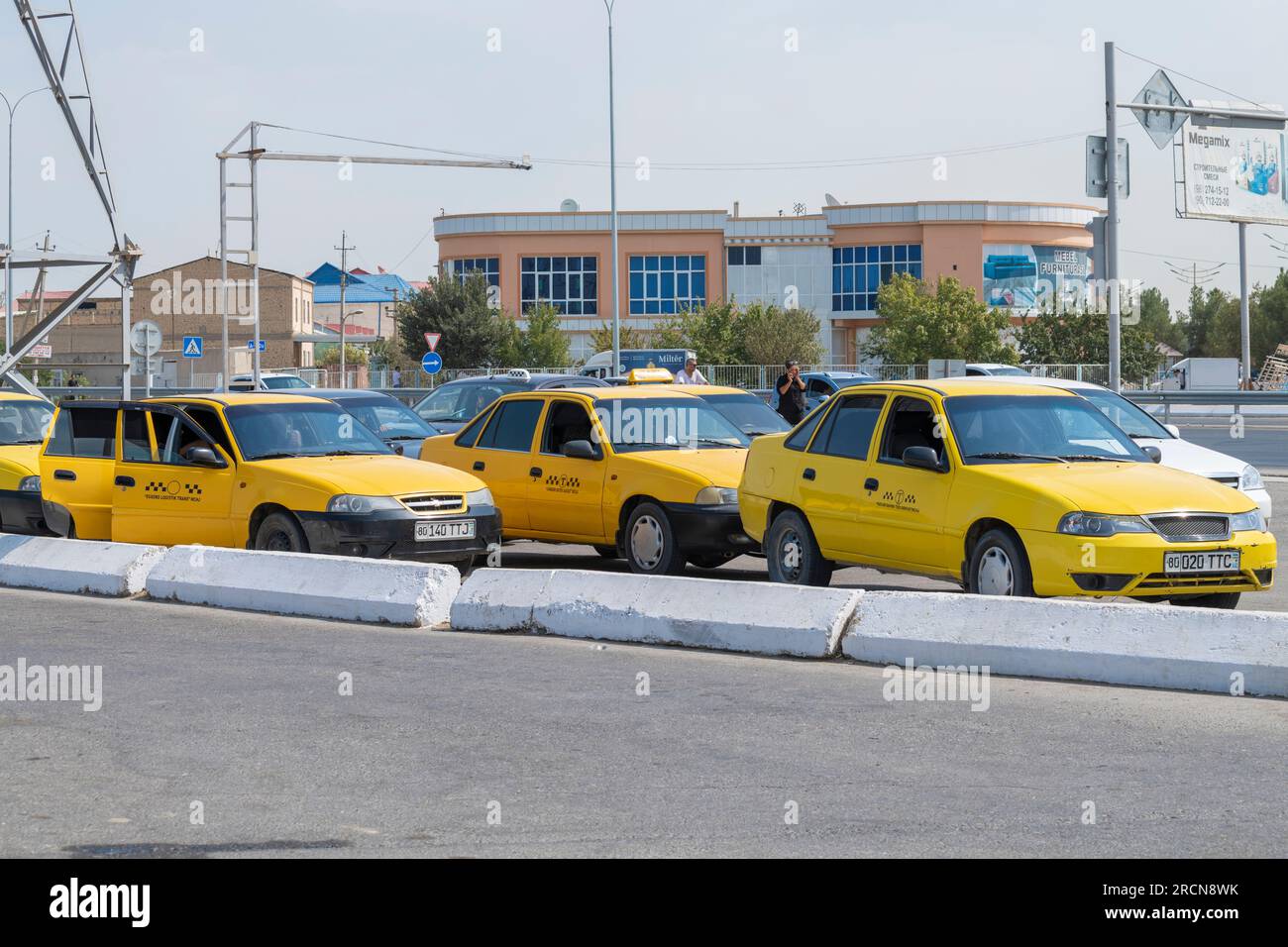BUKHARA, UZBEKISTAN - SEPTEMBER 10, 2022: Daewoo Nexia taxi cars on a city street waiting for passengers on a sunny day Stock Photo