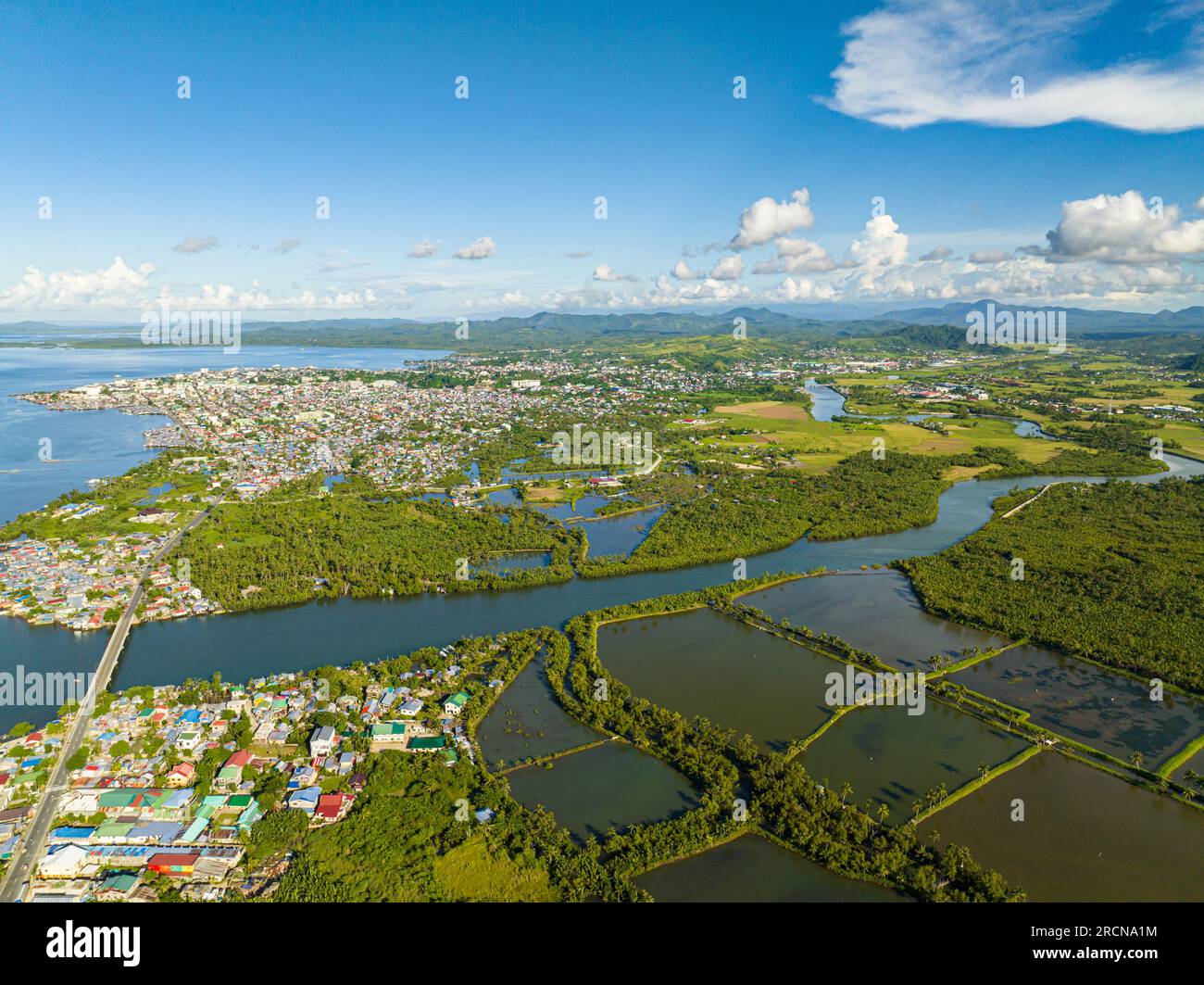 Air survey of beautiful Coastal City residential area and rainforest with river. Surigao, Philippines. Mindanao. Stock Photo