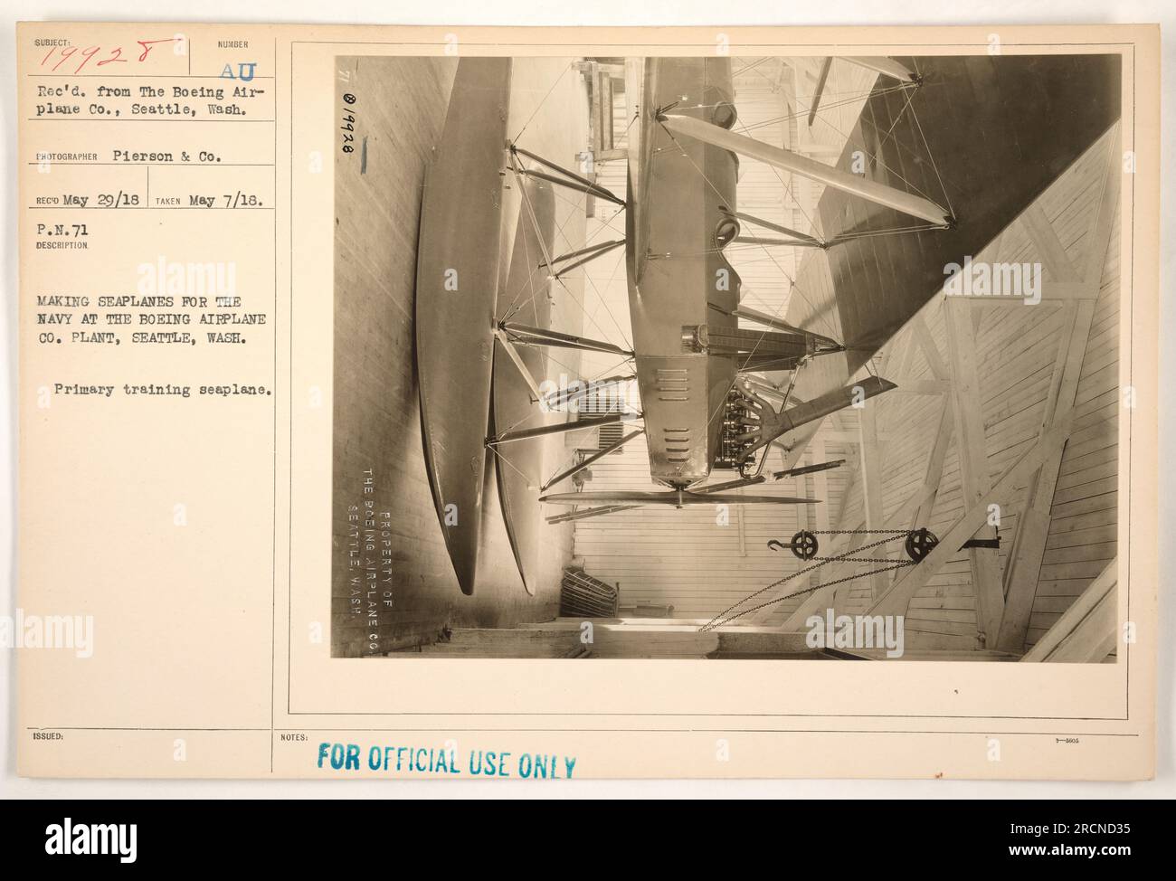 At the Boeing Airplane Co. plant in Seattle, Washington, workers are seen making seaplanes for the Navy during World War I. The seaplanes serve as primary training aircraft for the military. This photograph bears the description 'P.N.71' and is stamped with the notes 'PROPERTY OF FOR OFFICIAL USE ONLY.' Stock Photo