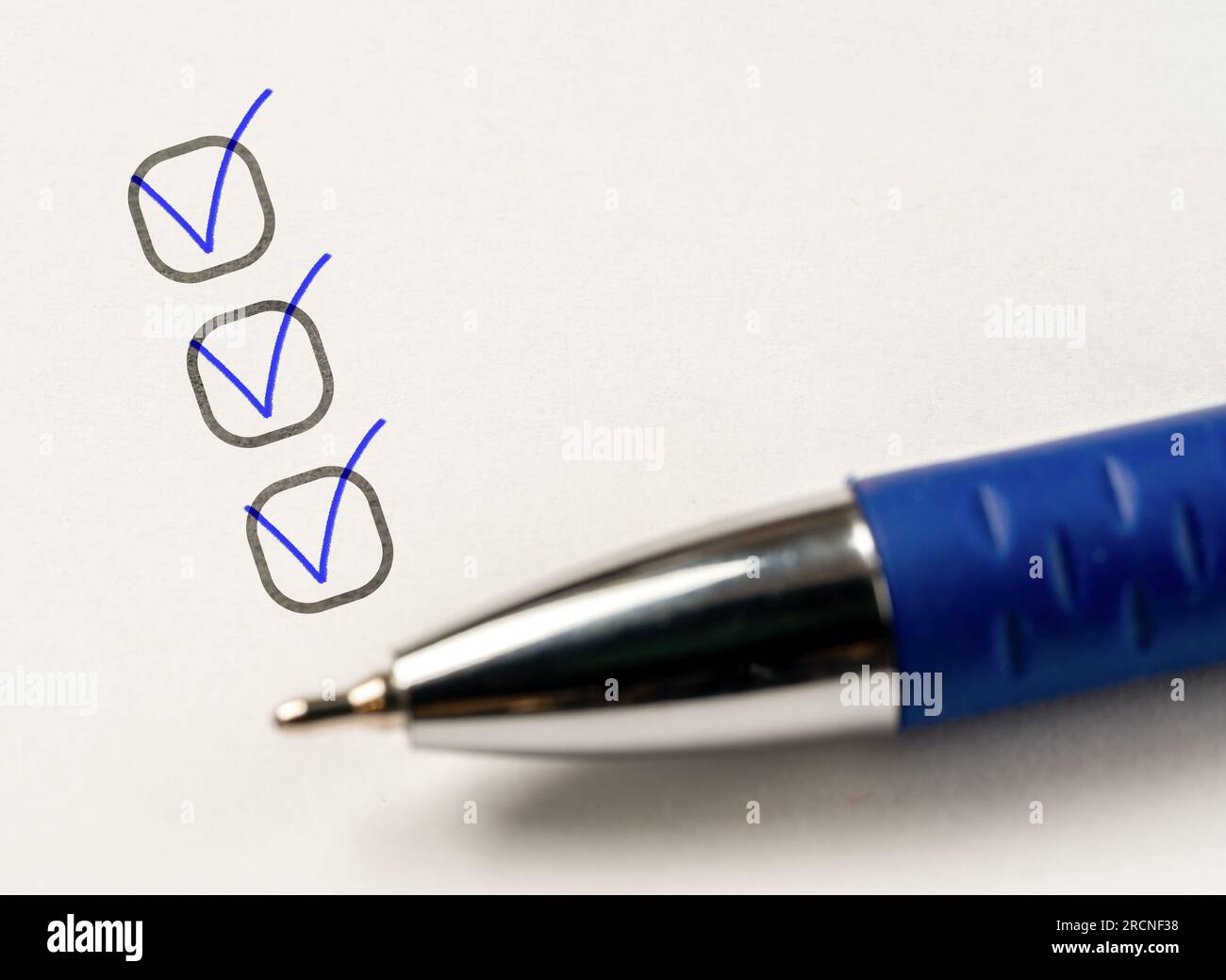 three checkboxes. hand with pen writing check mark on Checklist
