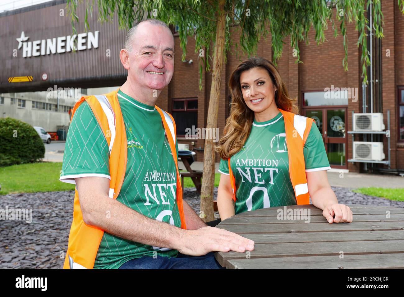 EDITORIAL USE ONLY Manchester United fan, Kym Marsh and Manchester City fan, Craig Cash put their differences aside and don green shirts during a tour of HEINEKEN UK's flagship Manchester brewery to celebrate a £25m investment into the brewery in support of the company's global net zero 2030 ambitions. Issue date: Sunday July 16, 2023. Stock Photo