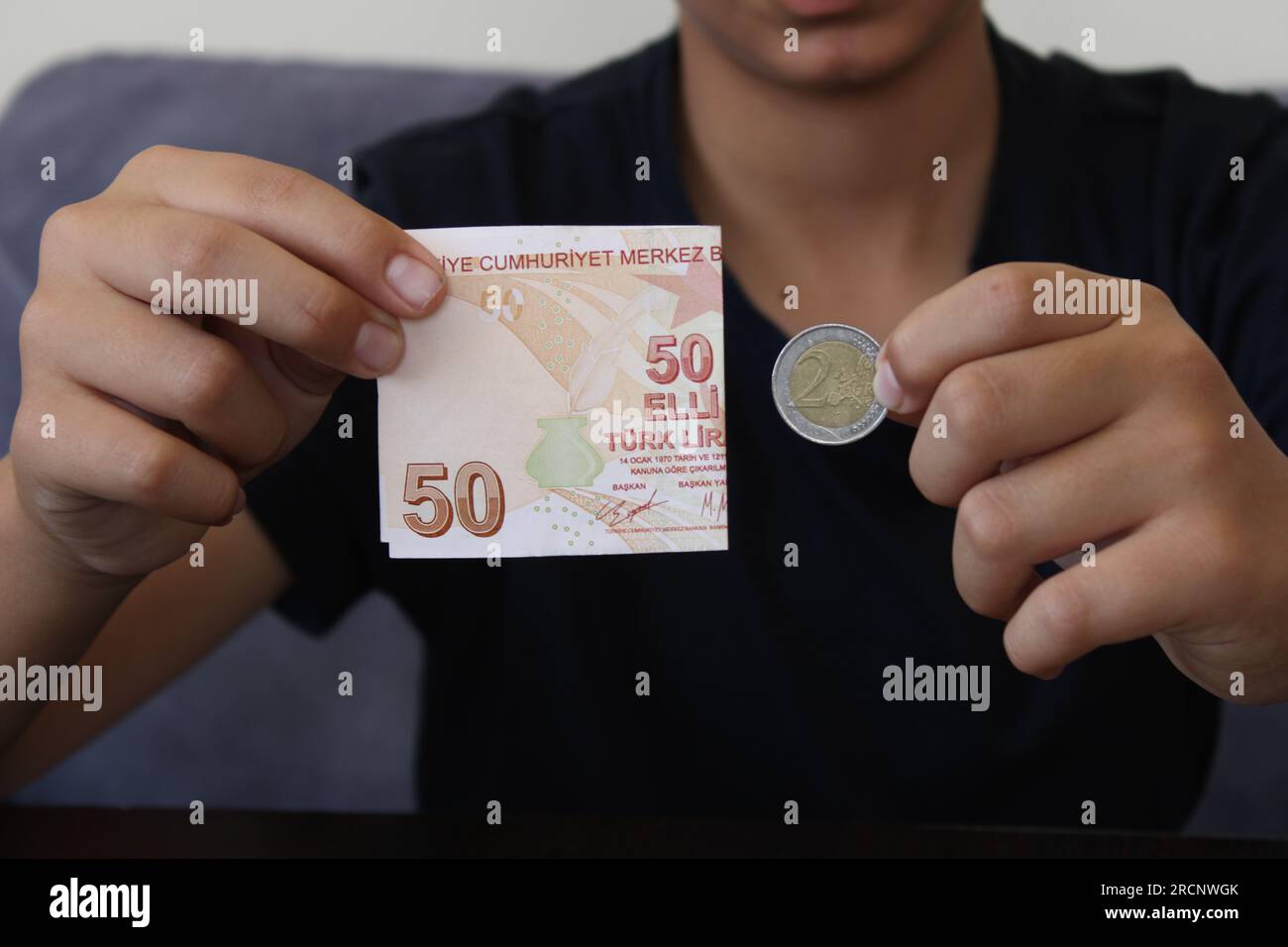50 Turkish lira and 2 euro on black background. The worthlessness of the Turkish currency