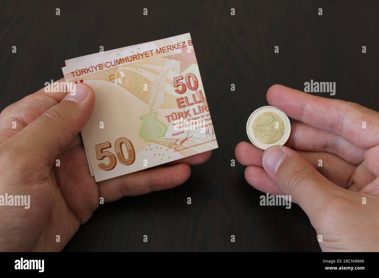50 Turkish lira and 2 euro on black background. The worthlessness of the Turkish currency