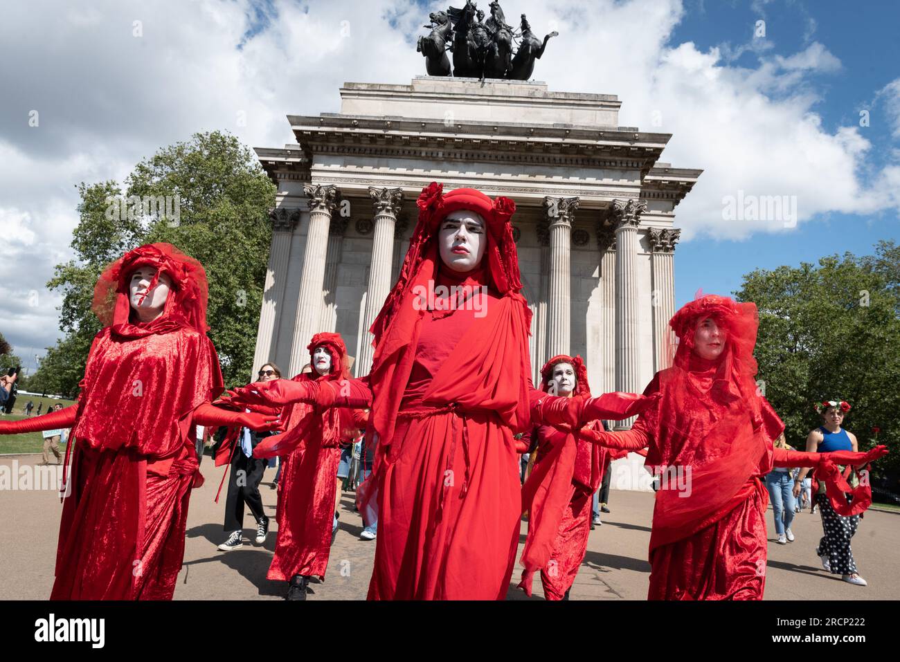 London, UK. 15 July, 2023. The Red Rebel Brigade activist mime troupe walk by Wellington Arch during a protest against the proposed development of the Rosebank oil field by Norwegian state-owned oil company Equinor which, campaigners say, threatens both climate targets and marine wildlife. Located 130 kilometres west of the Shetland Islands it is the biggest undeveloped oil field in the North Sea. After a rally at the Department for Energy Security & Net Zero (DESNZ) many marched to the Equinor HQ in Paddington. Credit: Ron Fassbender/Alamy Live News Stock Photo