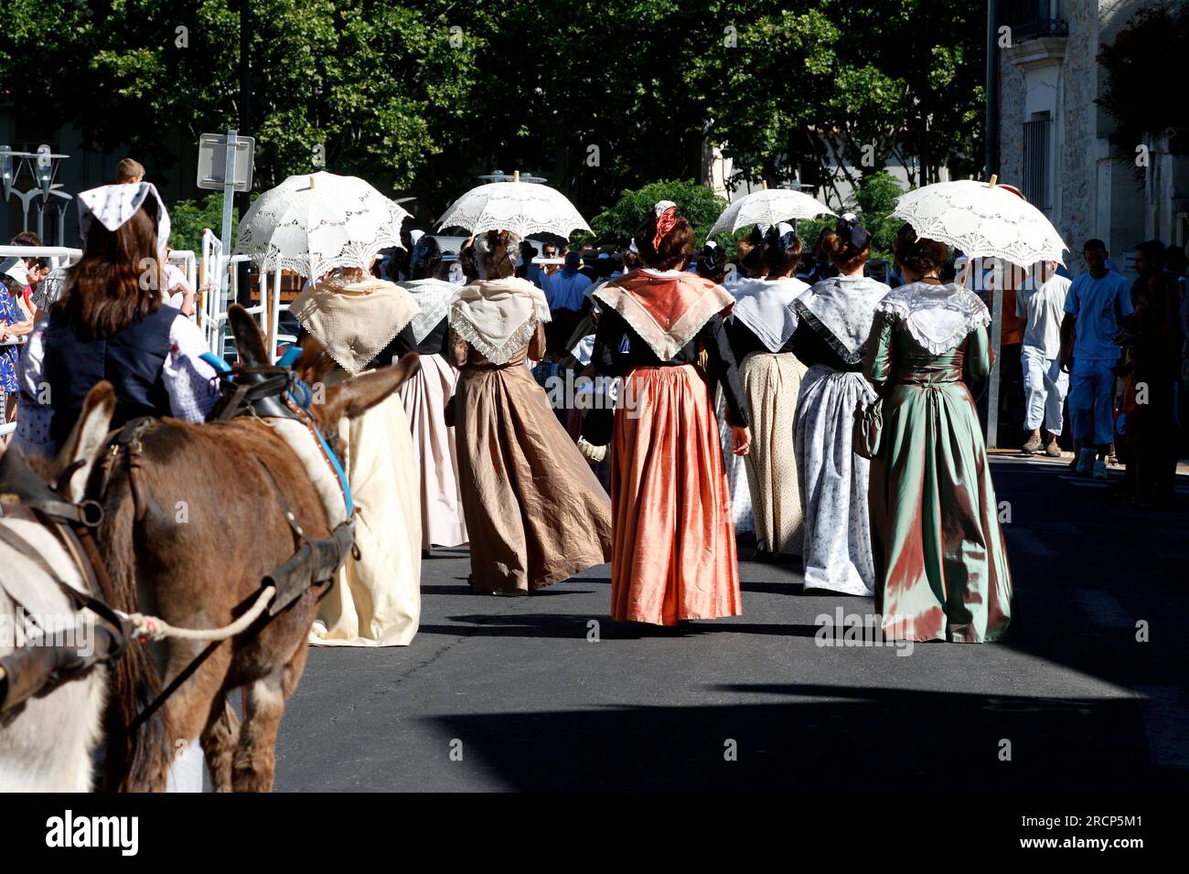 Village votive festival. Parade of Arlesiennes. Lunel, Occitanie, France Stock Photo