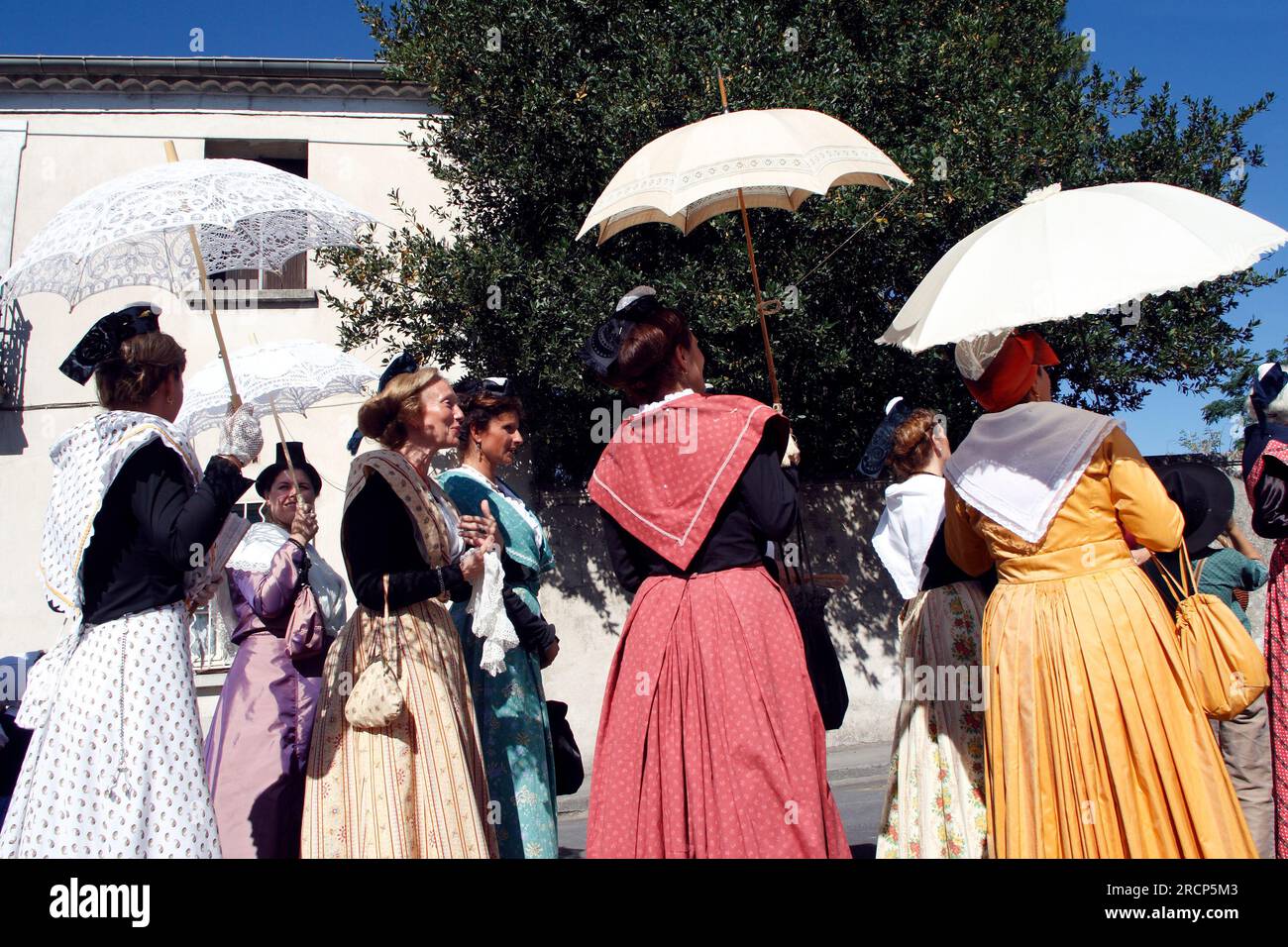 Village votive festival. Parade of Arlesiennes. Lunel, Occitanie, France Stock Photo