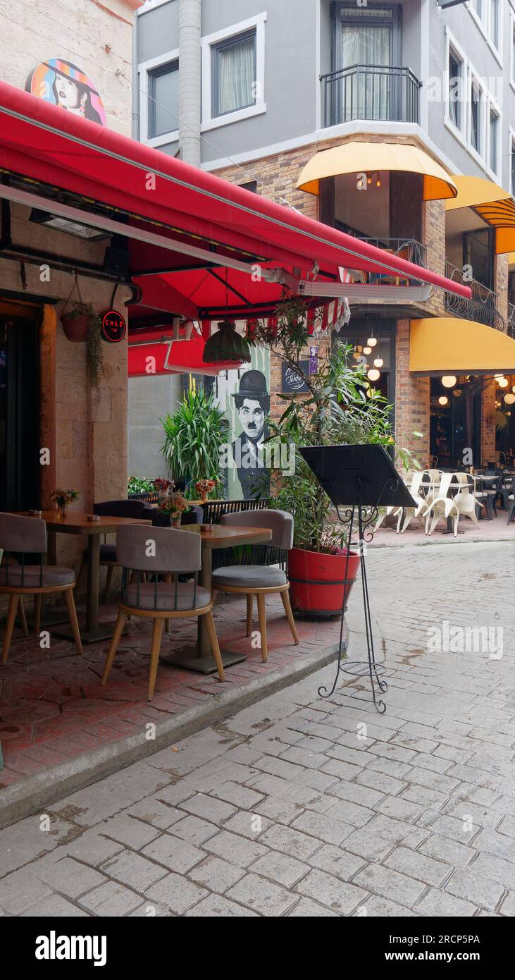 Street in the Karakoy neighbourhood of Istanbul with a cafe/restaurant and a Charlie Chaplin illustration on a wall Stock Photo
