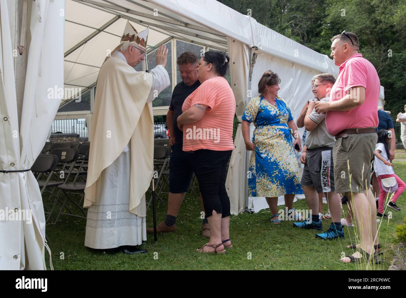 Open air church service  Catholic Bishop of Wrexham, the Right Reverend Peter M Brignall. He is blessing devout Catholic Irish Travellers after the service at Saint Winefride's Feast Day Pilgrimage. Holywell, Flintshire, Wales 25th June 2023. 2000s UK HOMER SYKES Stock Photo